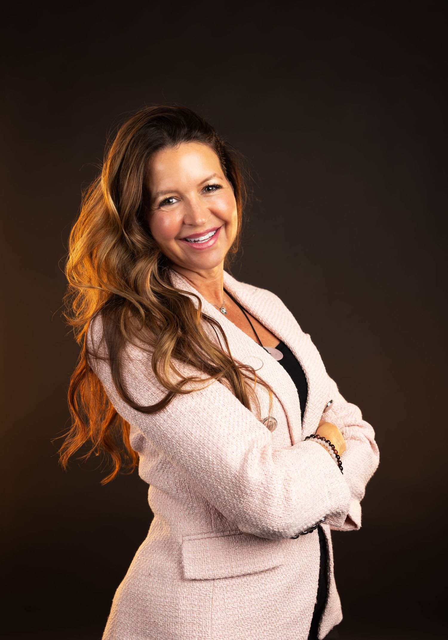 A person wearing a white knit sweater poses expressively against a dark background in a professional photo series.