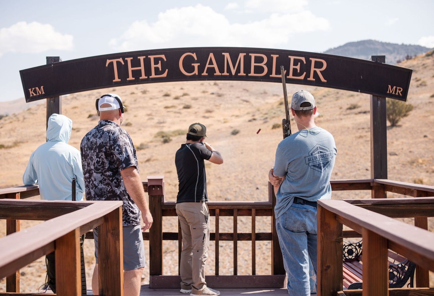 Wooden sign reading 'THE GAMBLER' mounted on a railing with desert landscape in the background.