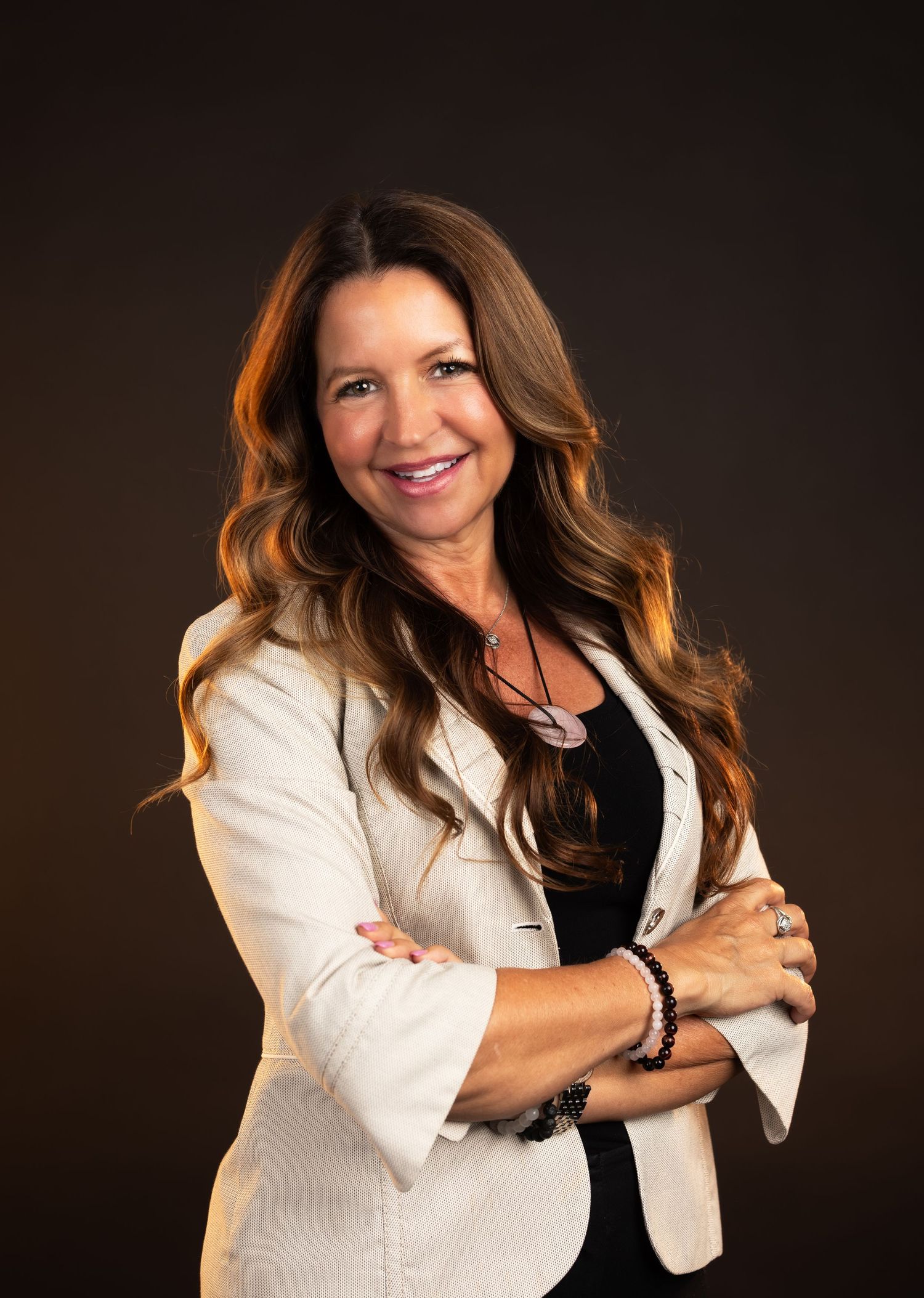 Professional headshots showing confident poses in white blazer against dark backdrop.