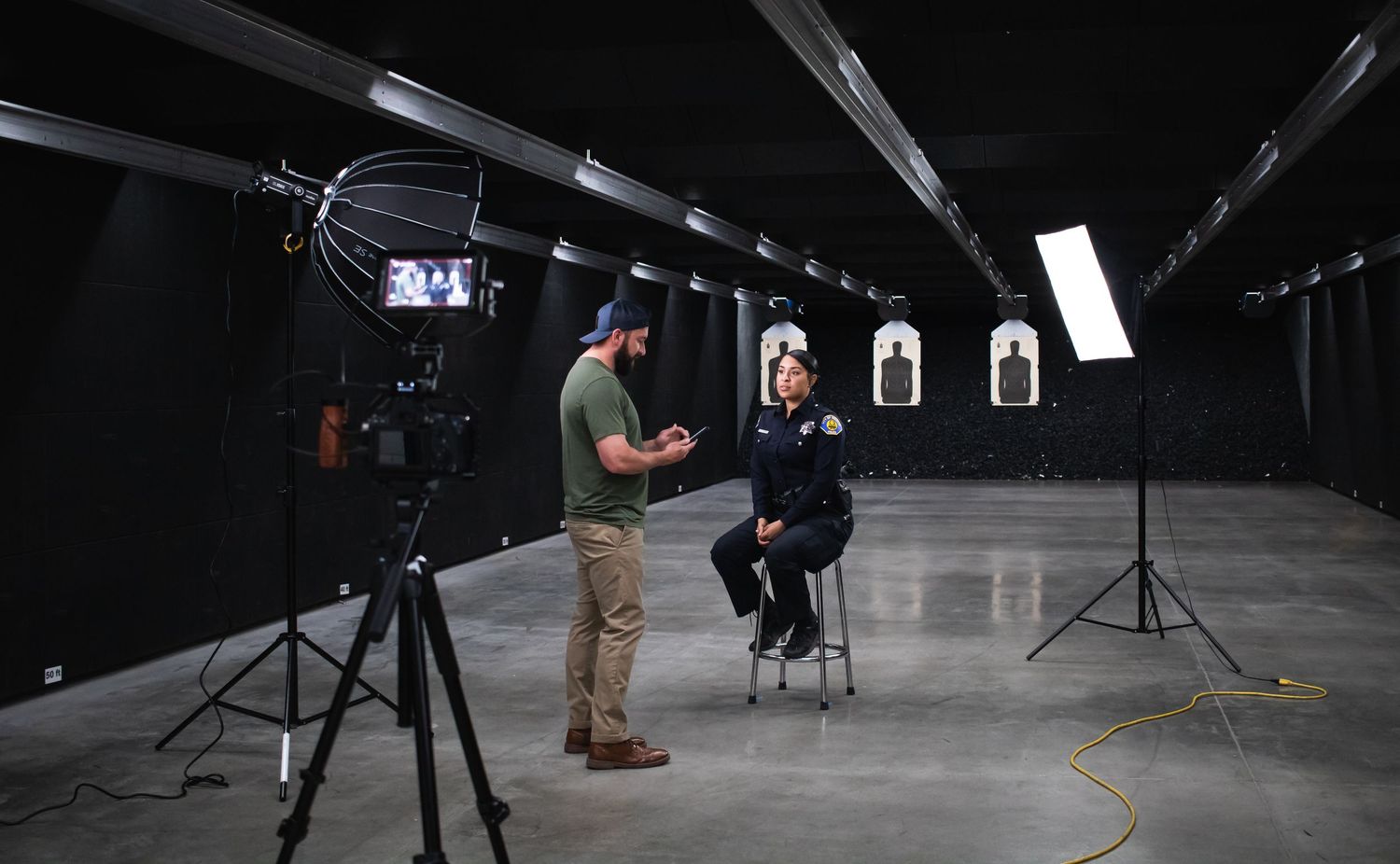 Behind the scenes photo shoot setup in dark studio space with lighting equipment and camera gear.