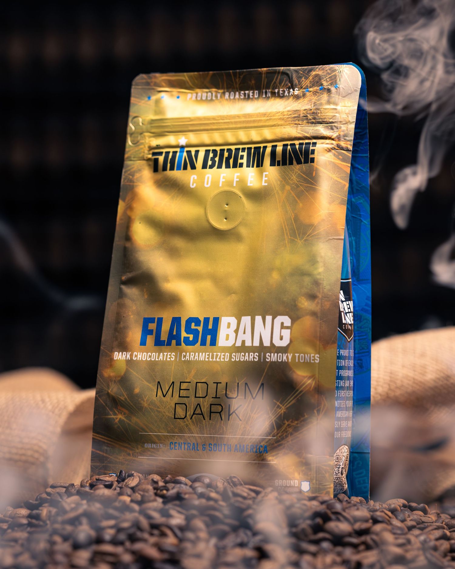 Coffee packaging for Flash Bang blend displayed with roasted beans and smoke effects.