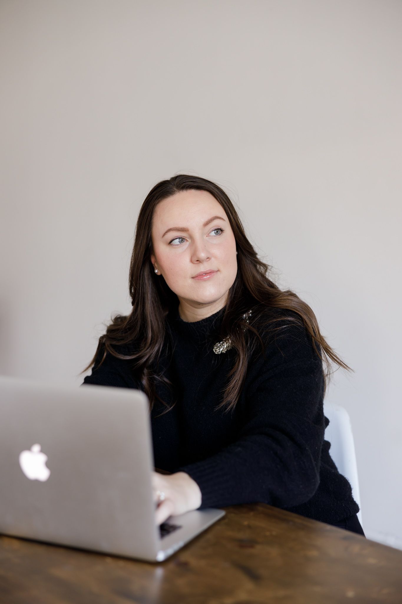 woman business real estate owner sitting at desk on computer looking out window for lifestyle branding photo in Seattle, WA