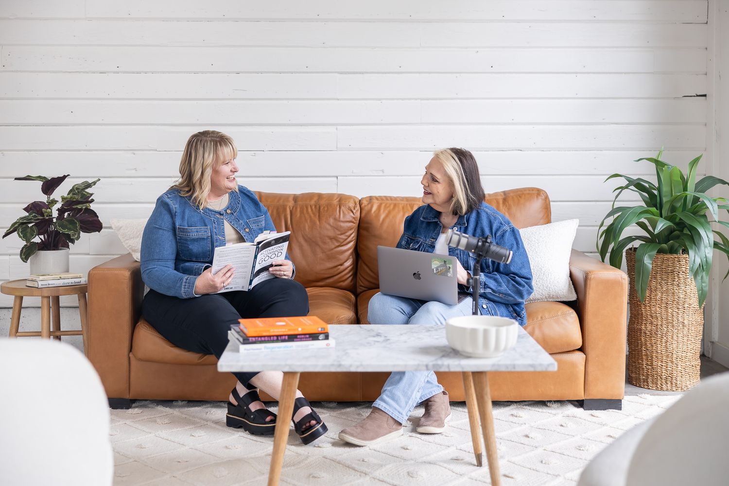 2 business women partner sitting on couch working on laptop and looking in book for lifestyle branding photo in Auburn, WA