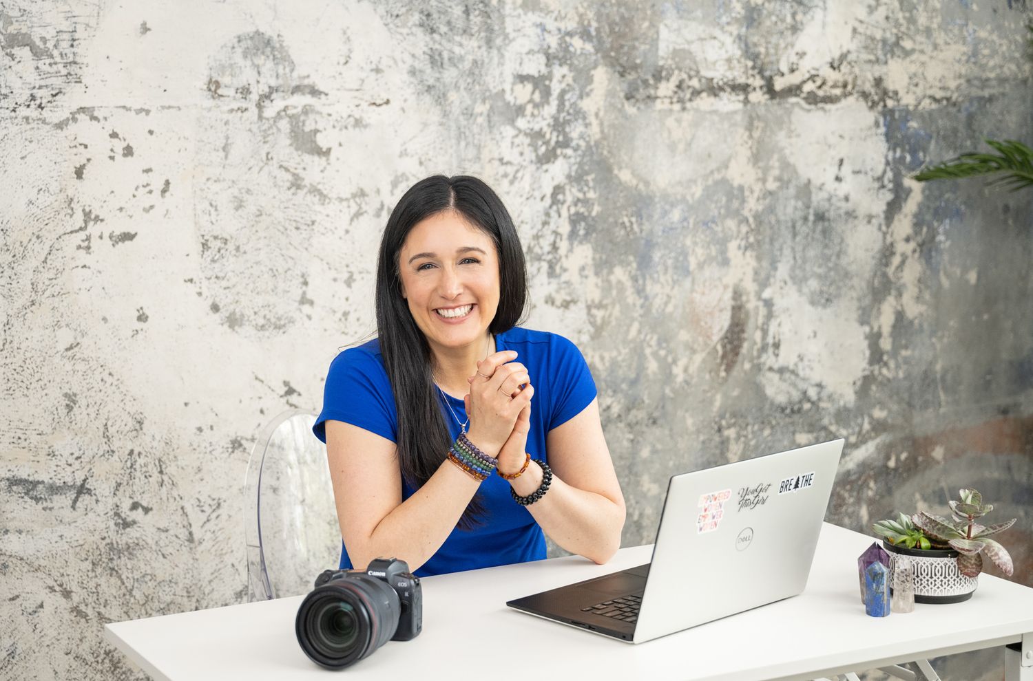 woman sitting at desk in front of laptop and camera smiling at camera in studio in Seattle, WA for personal branding lifestyle headshot