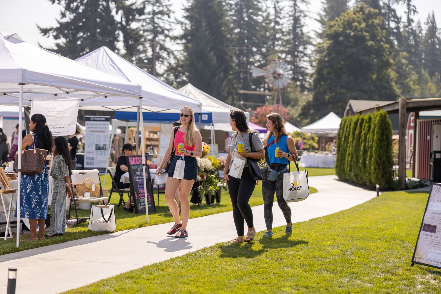 women's wellness community event photography in Redmond, WA 3 women walking through business booths laughing