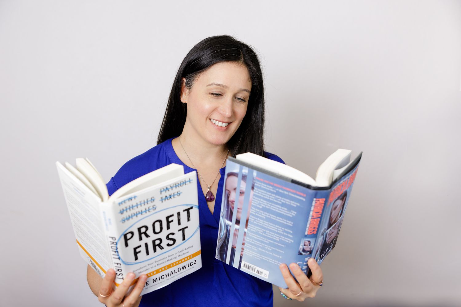 woman holding two open books in hands a business and urban fantasy book for lifestyle branding photo in Seattle, WA