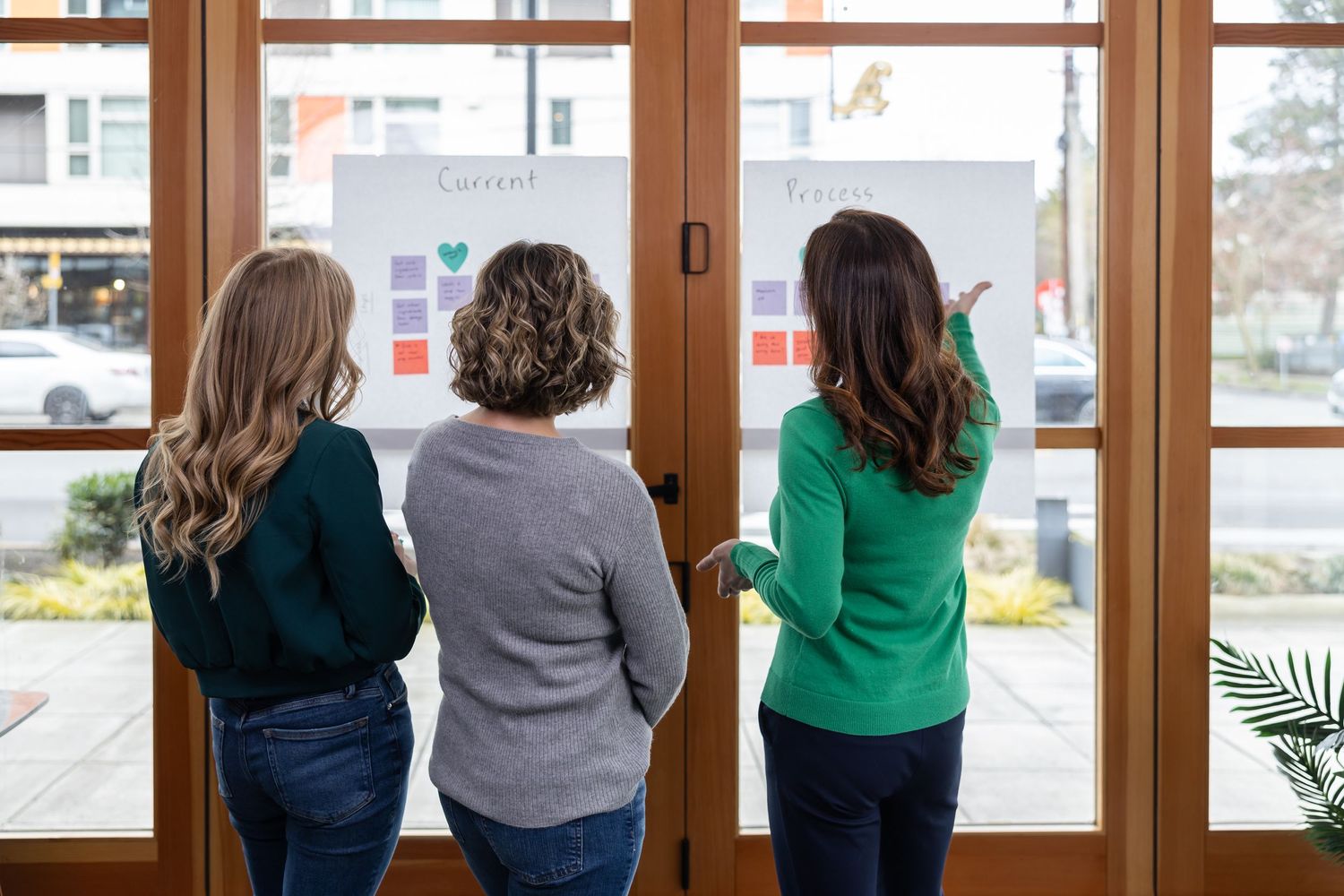 female business coach pointing at white board to other women about processes for lifestyle branding photo in Seattle, WA