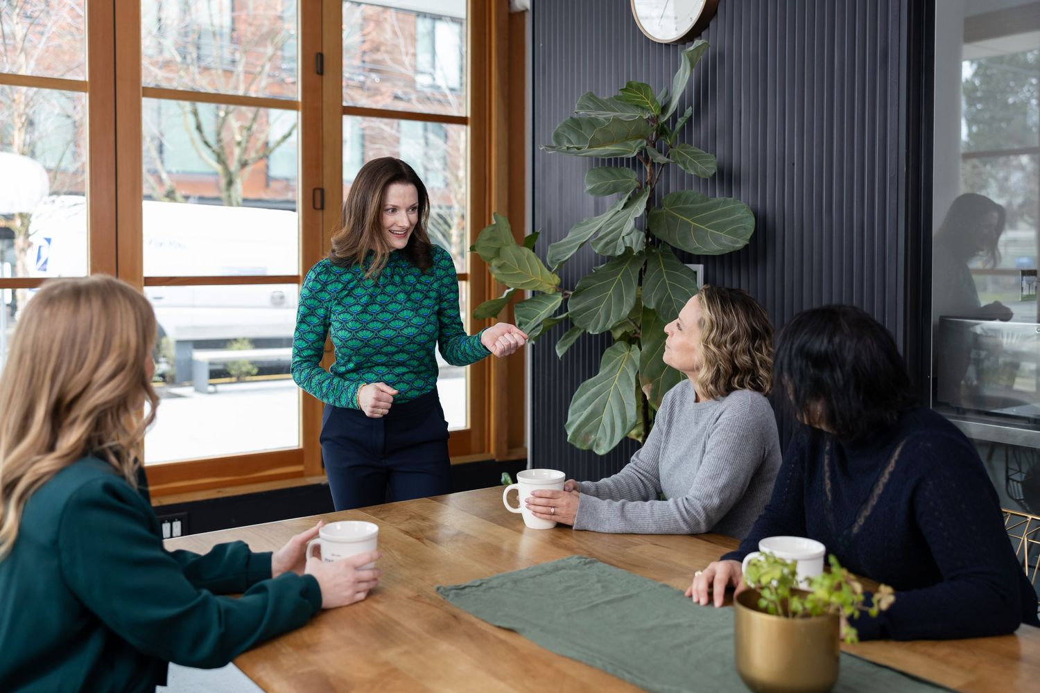 woman business coach presenting in front of 3 women businesses in cafe in Seattle, WA for lifestyle branding photo