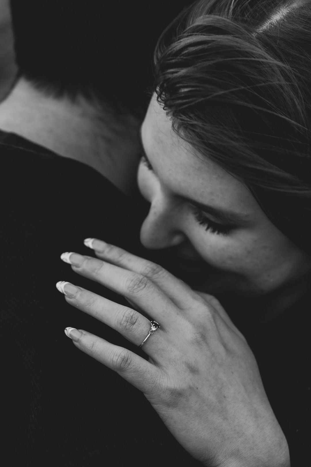 Intimate black and white engagement moment highlighting ring her details by Cleveland engagement photographer.