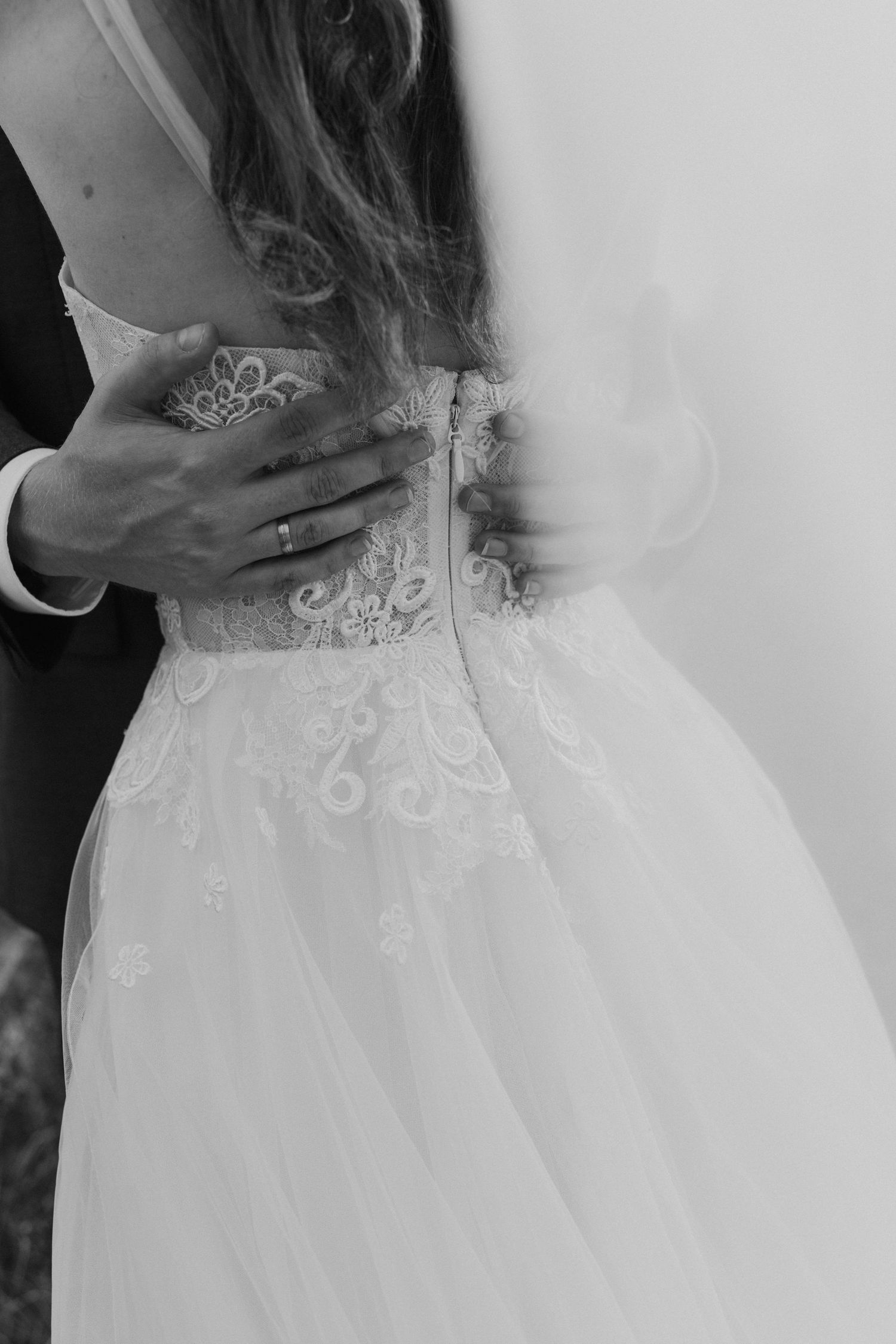 Detailed lace bodice of a white wedding dress shown in black and white with delicate embroidered patterns.