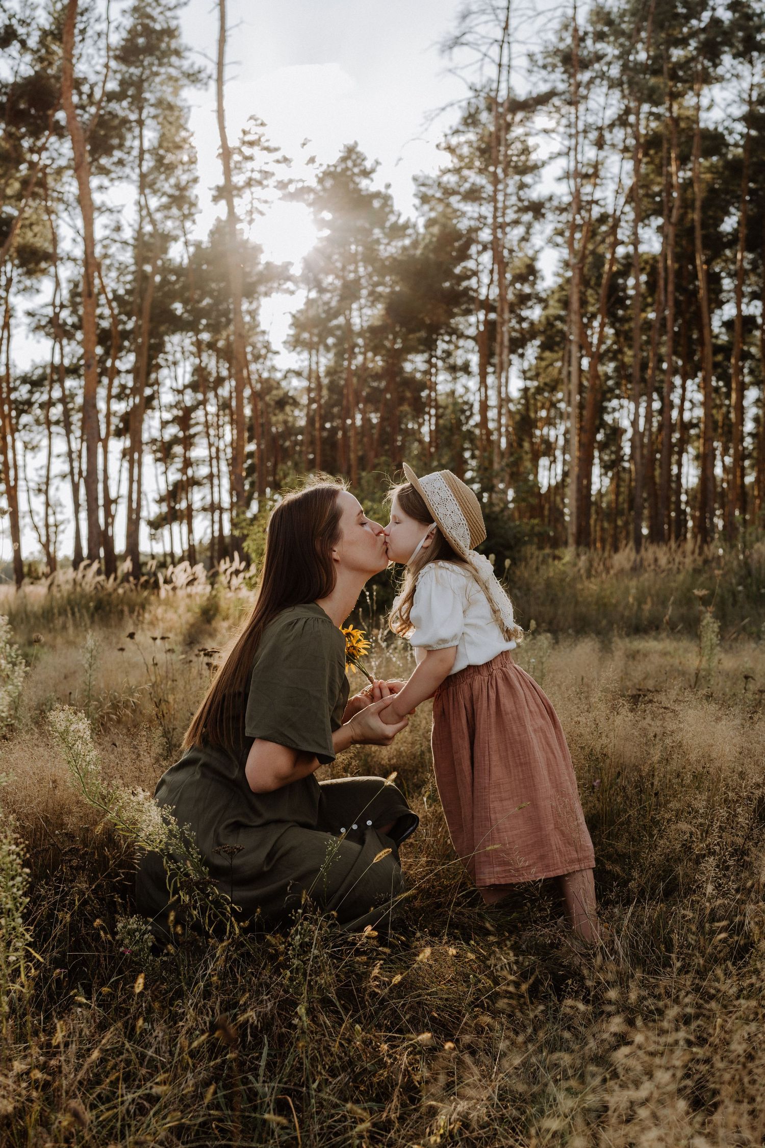 Tender moment shared in a sun-dappled forest clearing during golden hour.