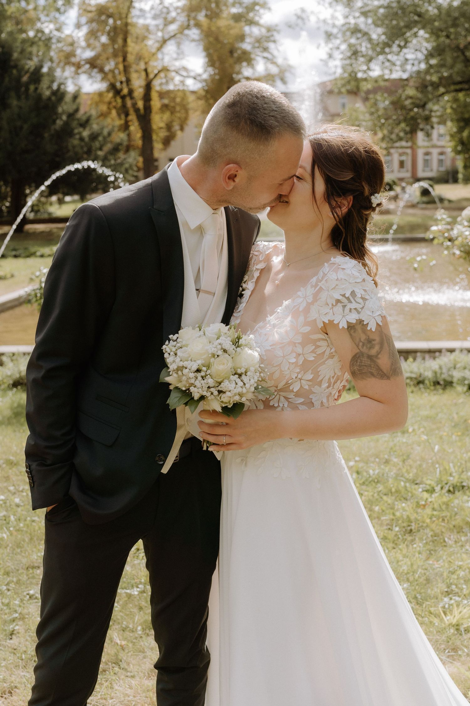 A sunny garden wedding scene with water fountains creating a romantic backdrop.