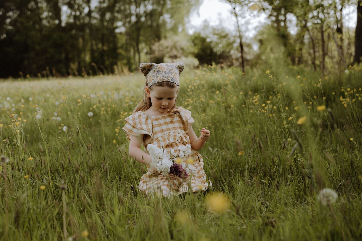 Child playing in wildflower meadow during summer.