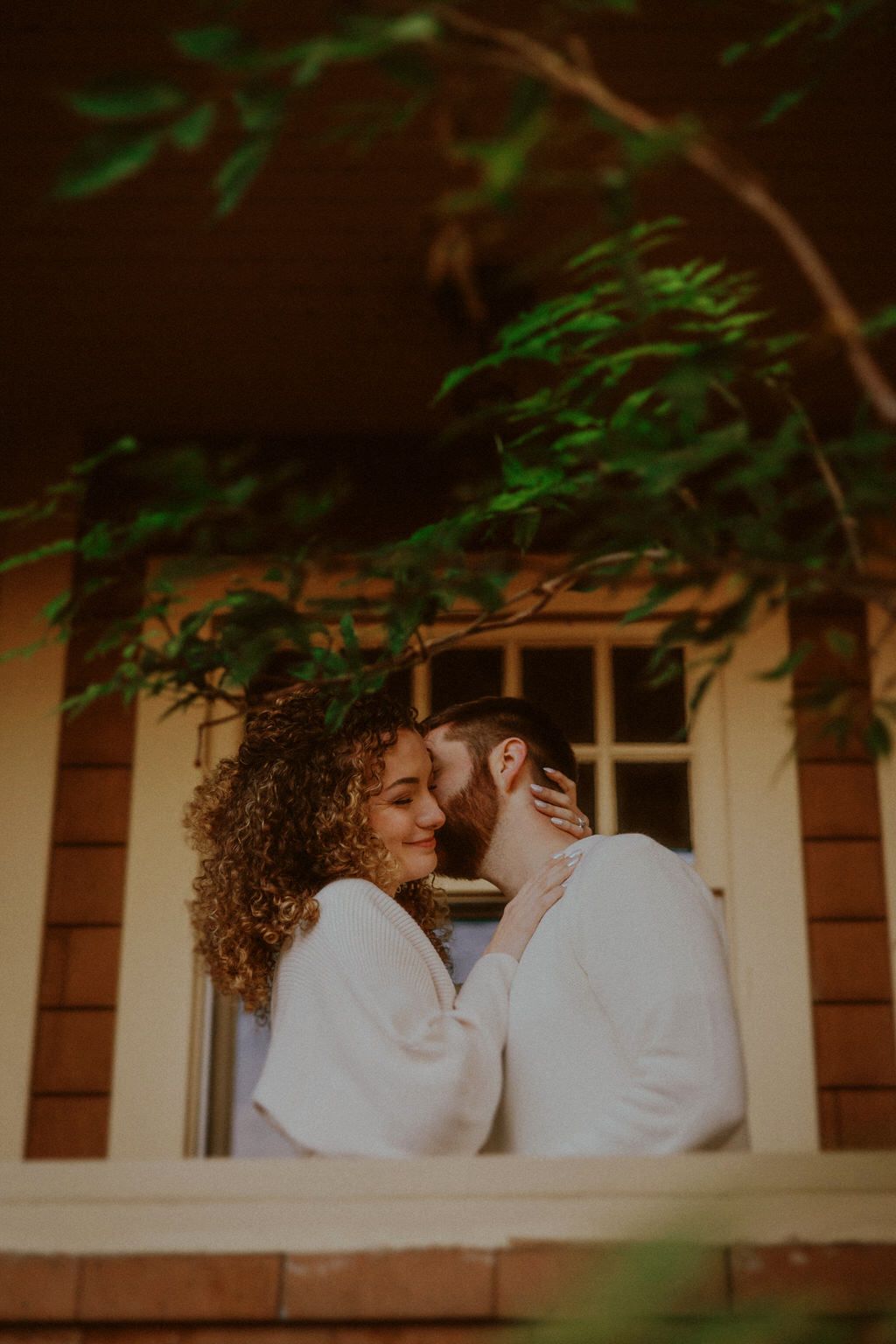 Romantic scene on a porch with white pillars and green vines.