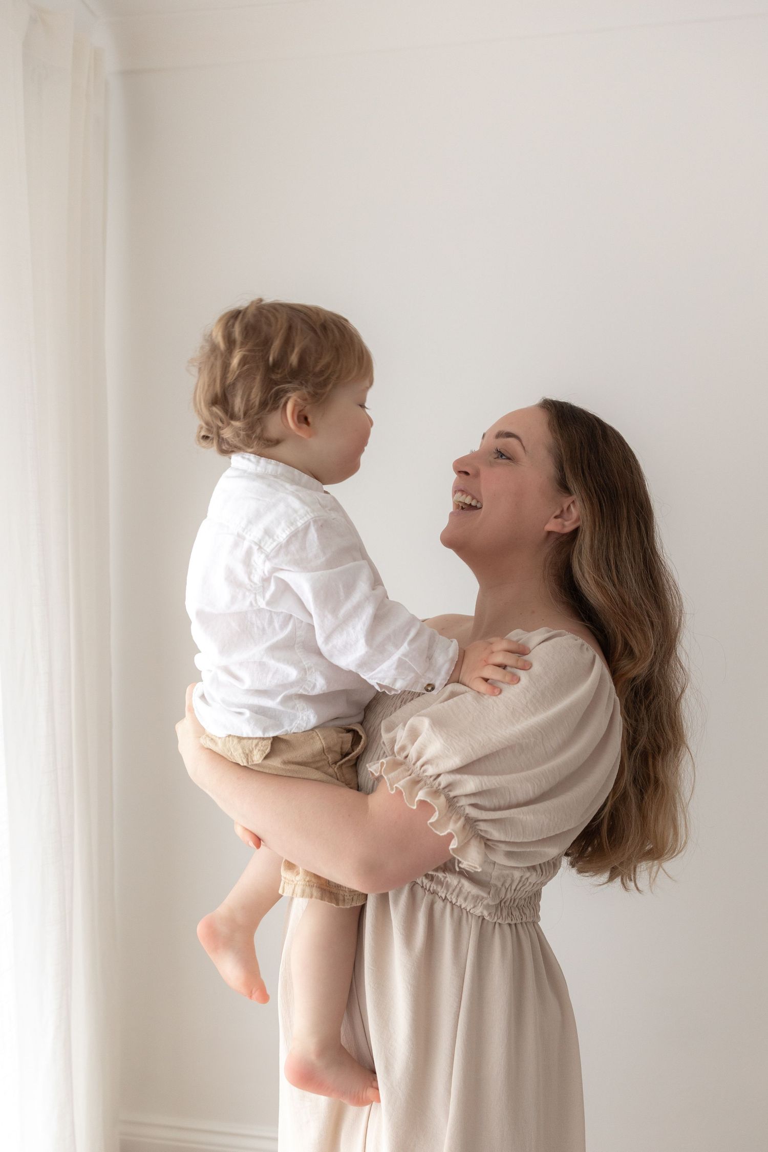 Heartwarming embrace between caregiver and child in white and beige outfits.
