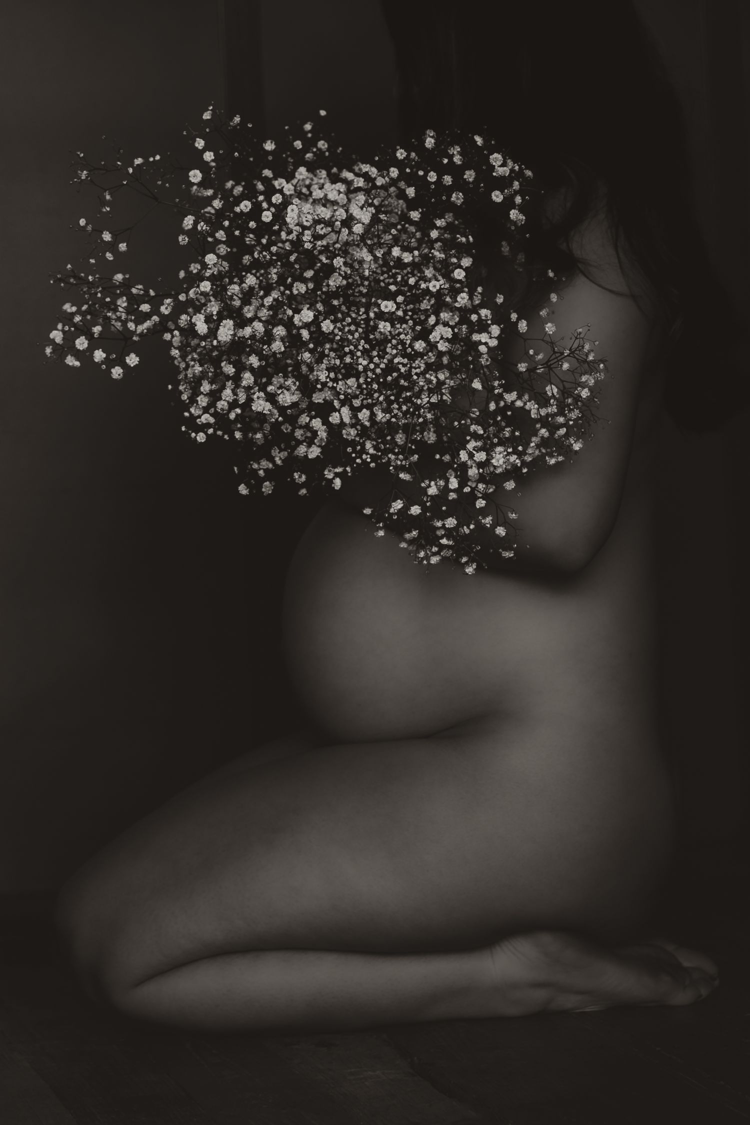 Artistic black and white photo of baby's breath flowers with silhouetted figure.