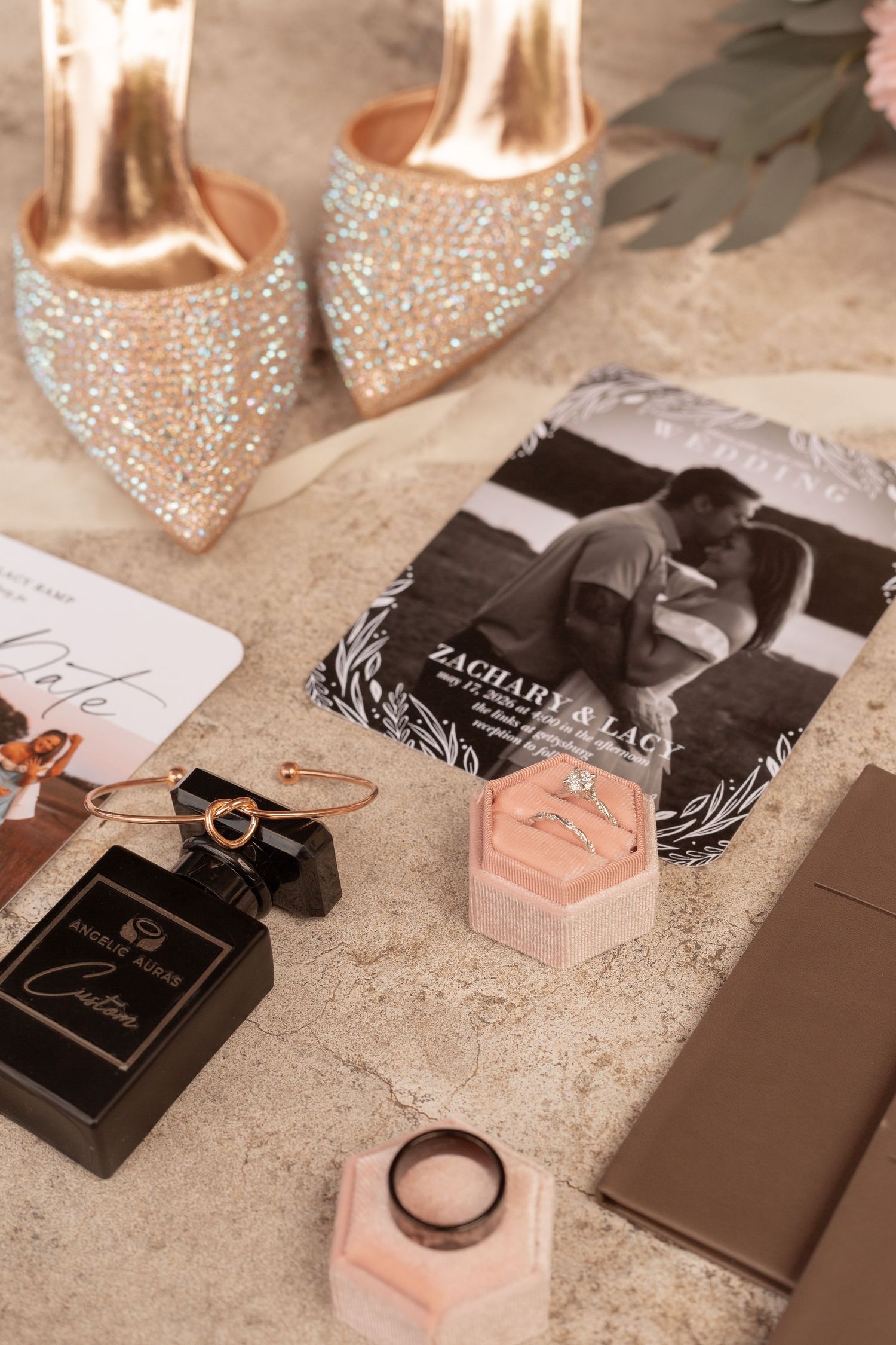 Wedding flat lay with glitter heels, ring box, perfume, gold bangle, and Zachary & Lacy save-the-date card.
