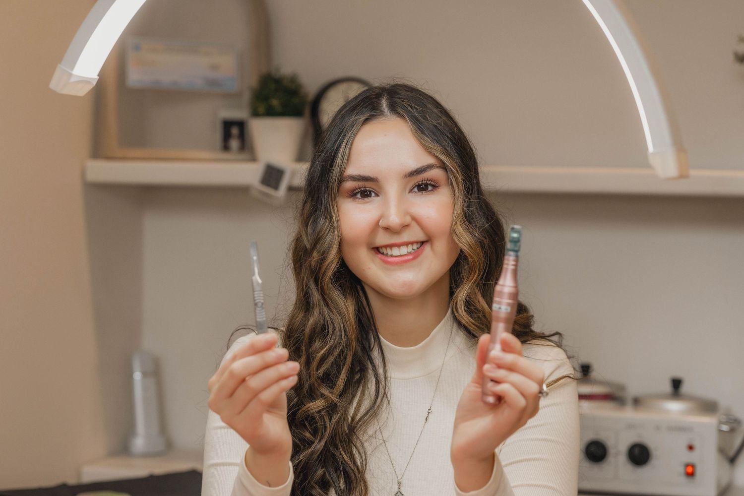 A person holding dental tools while smiling in a bright modern dental office setting.