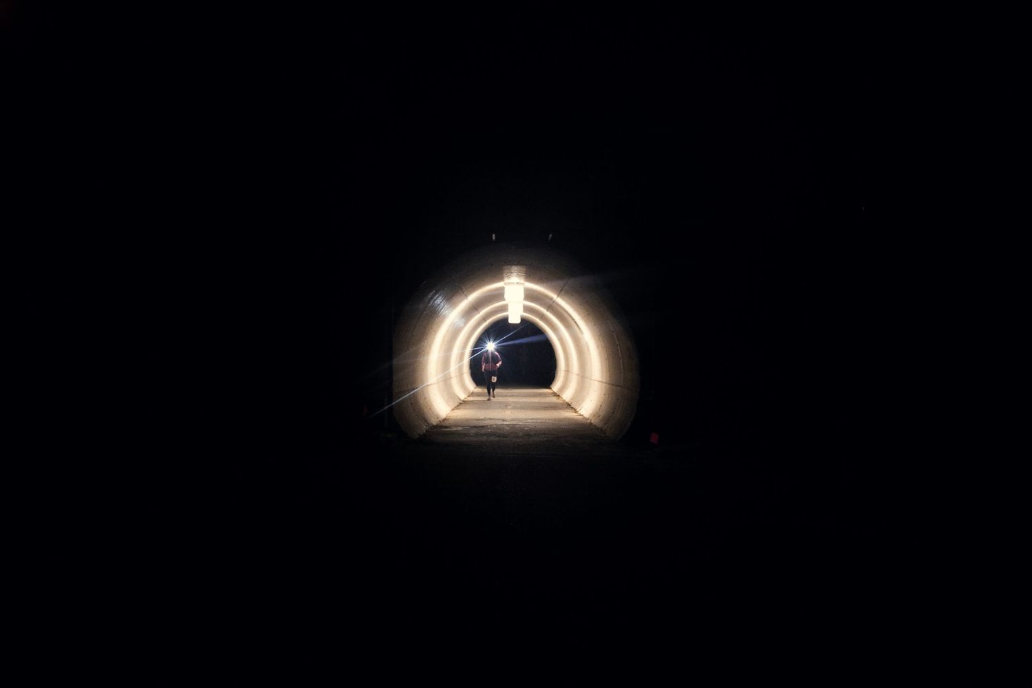 Light at the end of a dark tunnel creates circular glowing effect.