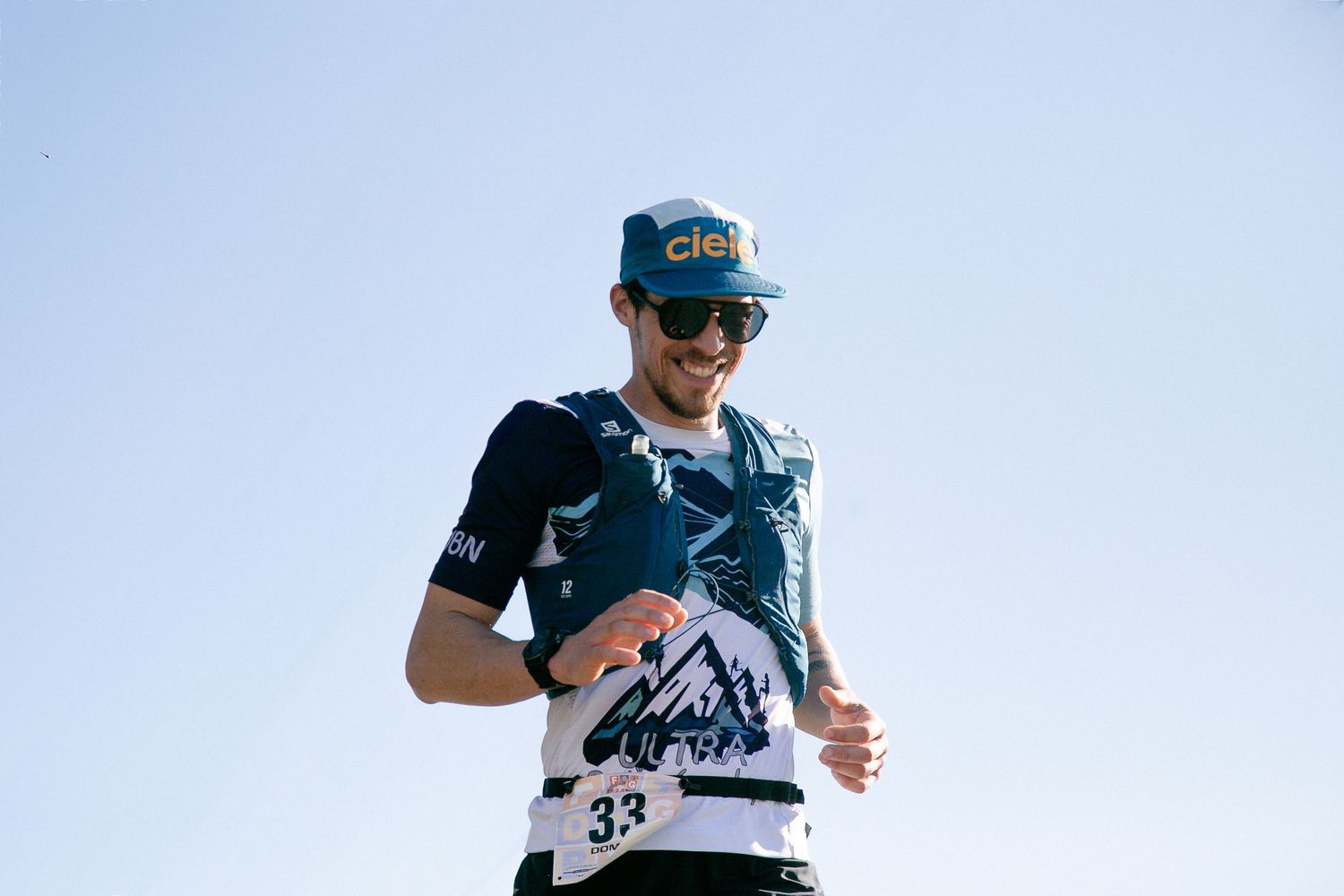 Runner wearing a blue cap and race number during an outdoor competition.