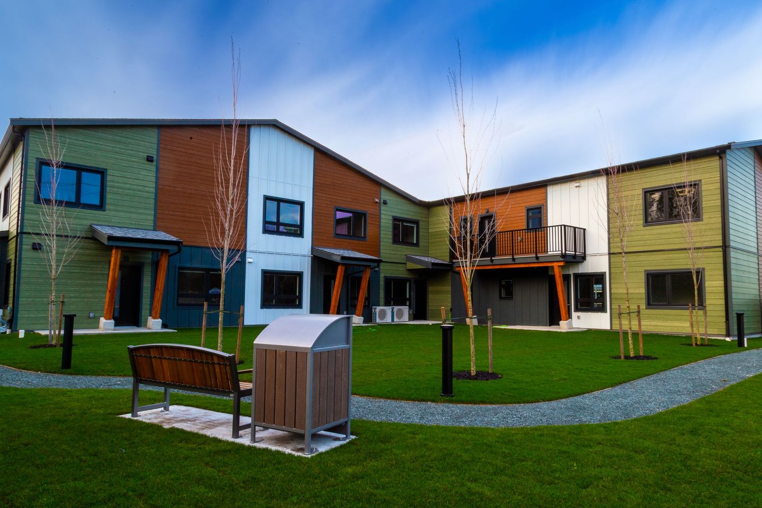 Contemporary multi-unit housing development with colorful facades and landscaped courtyard.