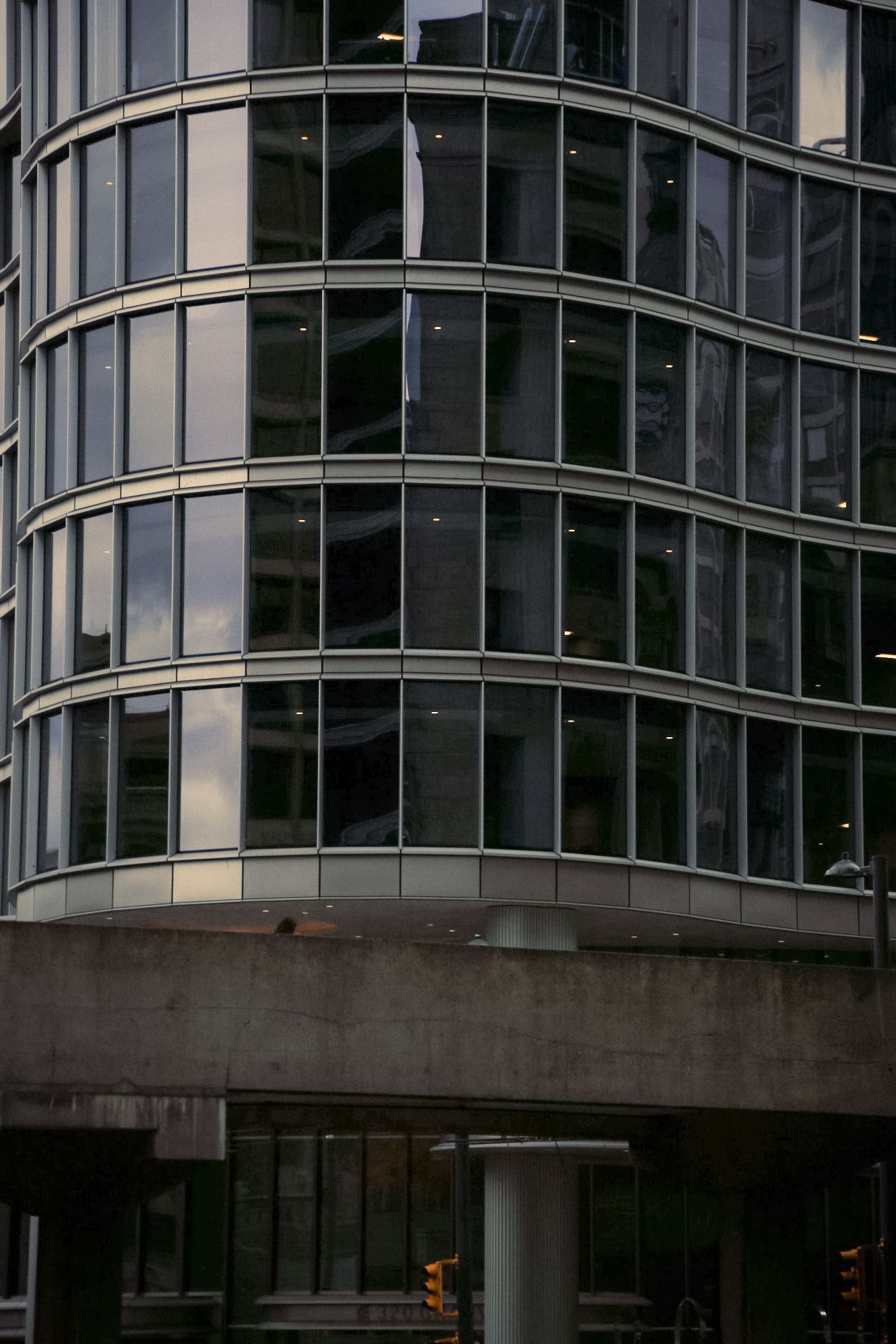 Curved glass exterior of a modern office building with horizontal architectural lines.