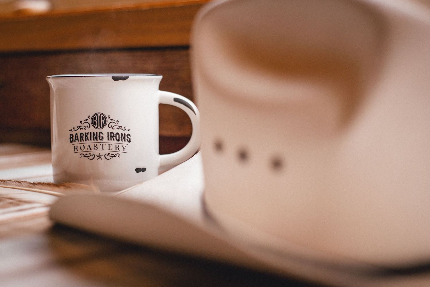 Vintage enamel coffee mug on wooden table with soft focus background.