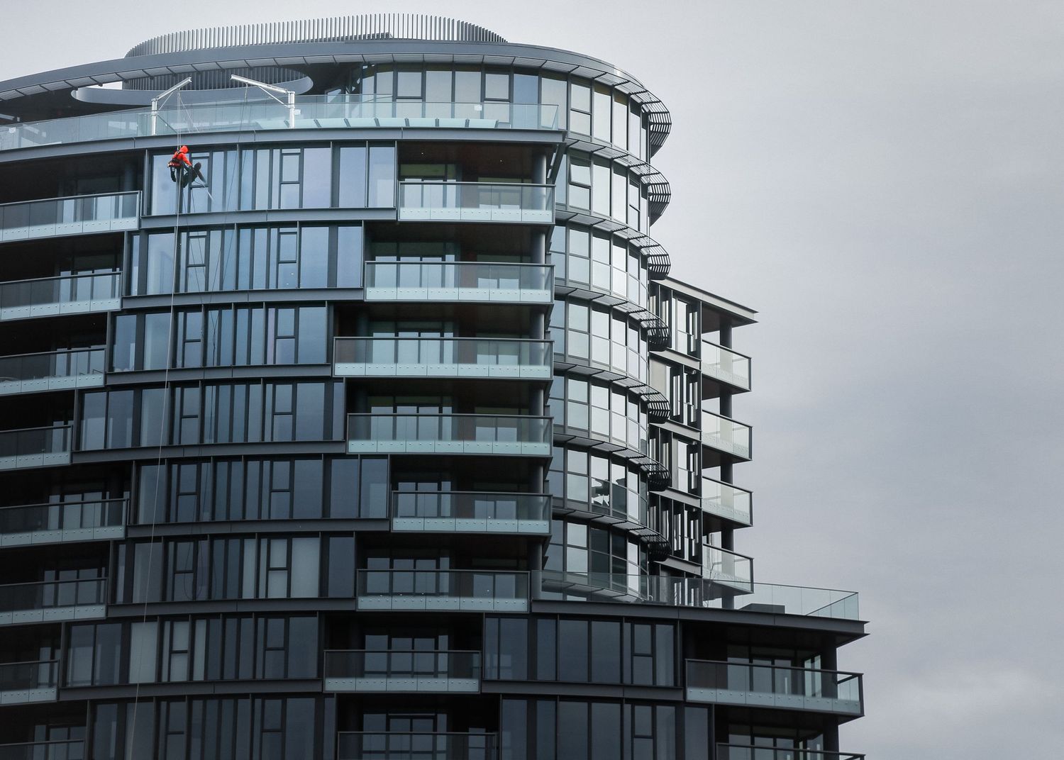 Contemporary high-rise residential building with curved architecture and glass balconies.