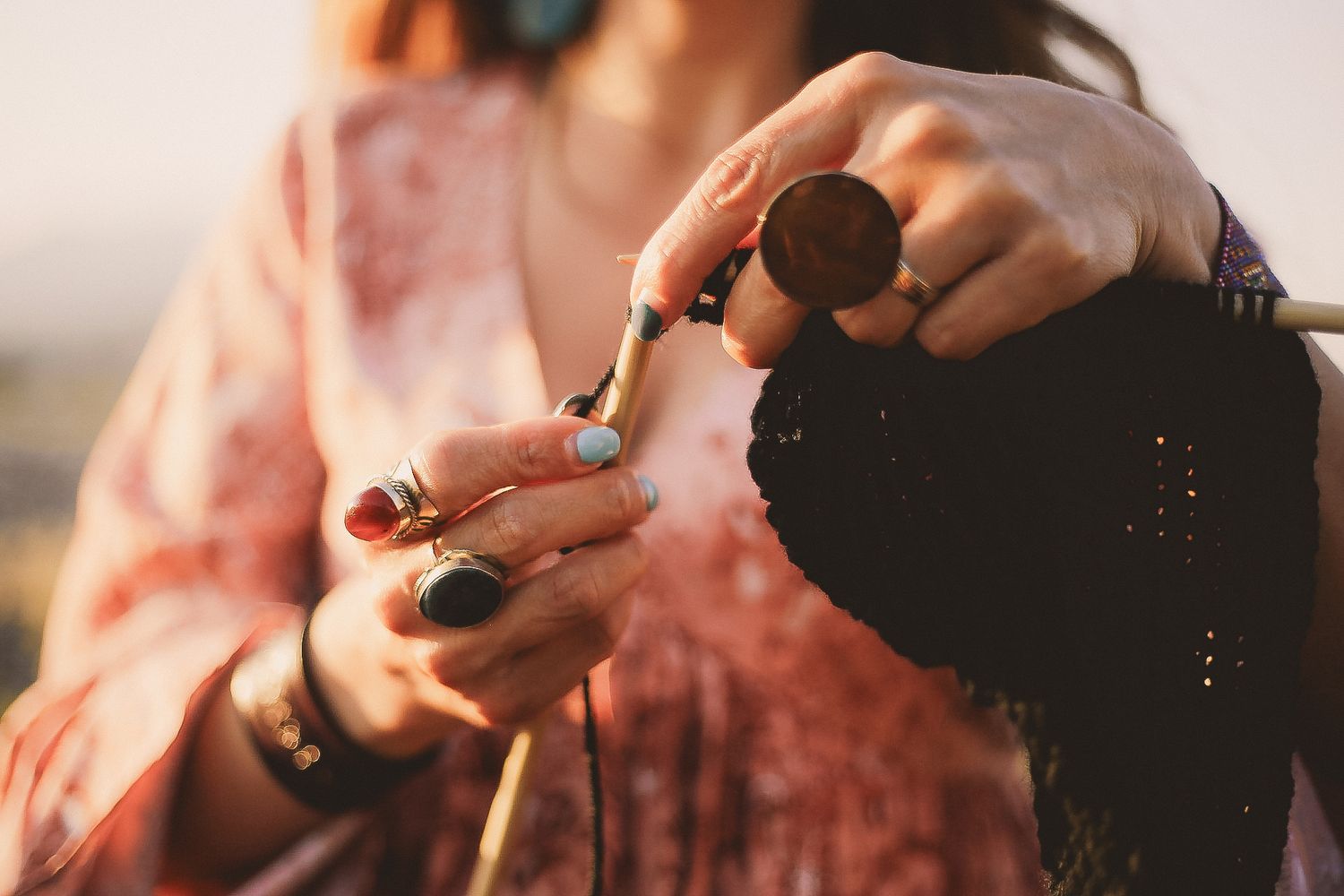 Close-up of hands holding and lighting a small object during golden hour.