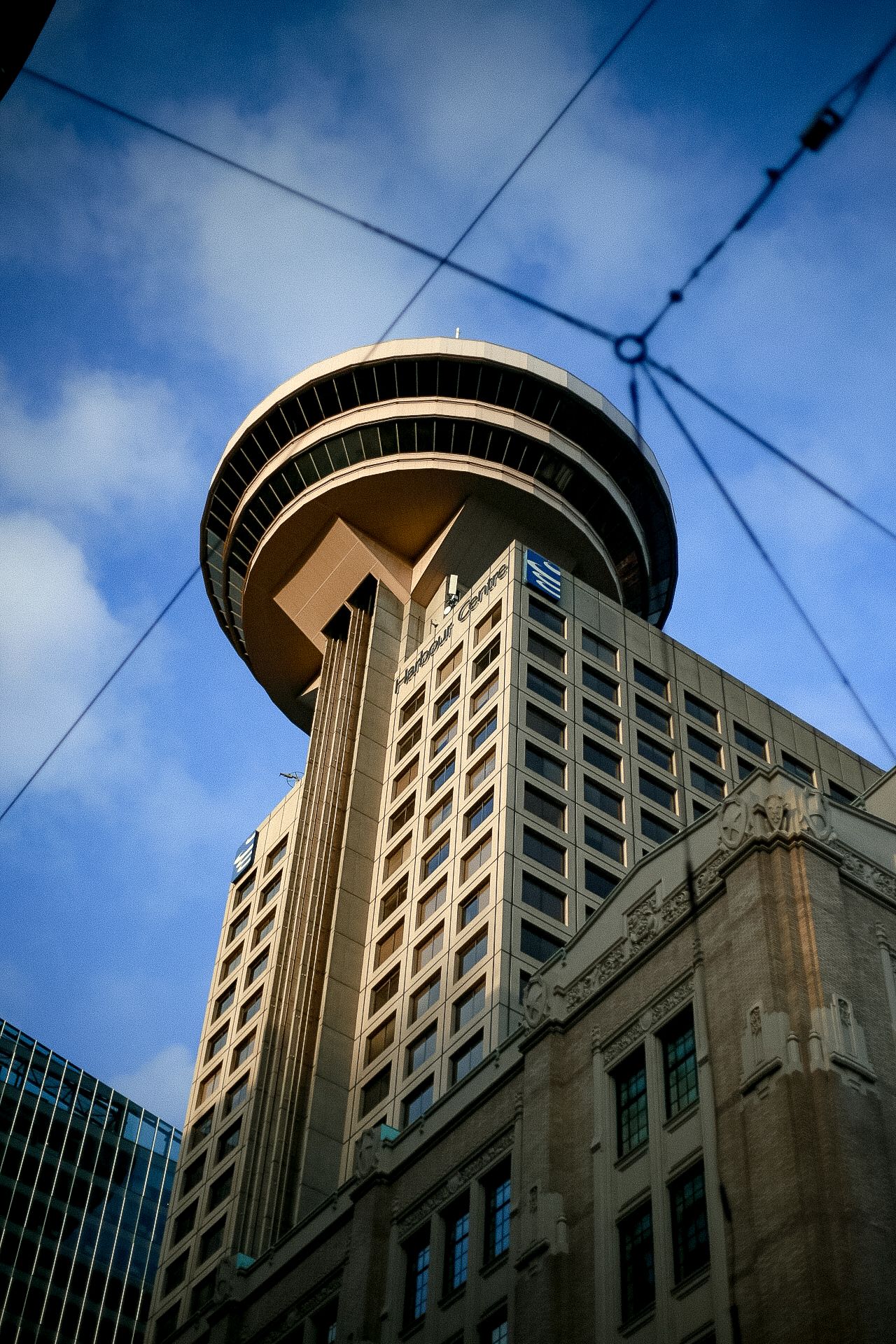 Harbour Centre tower in Vancouver with its distinctive observation deck against blue sky.