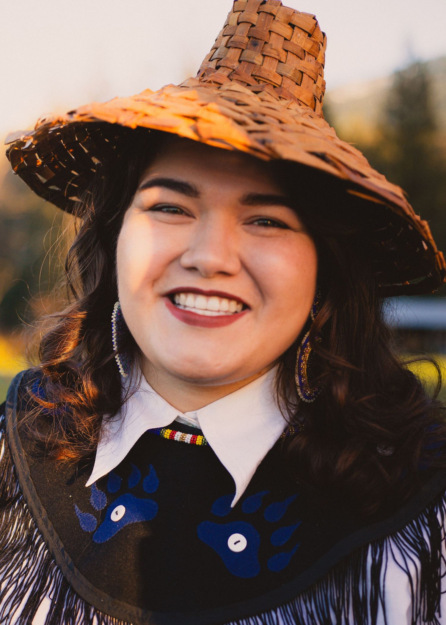 Traditional woven hat paired with formal attire and decorative accessories.