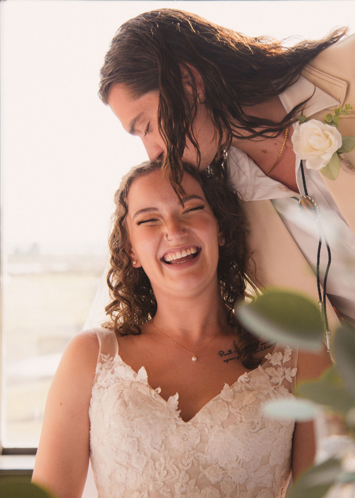 Candid moment of joy captured in natural light with white lace details.