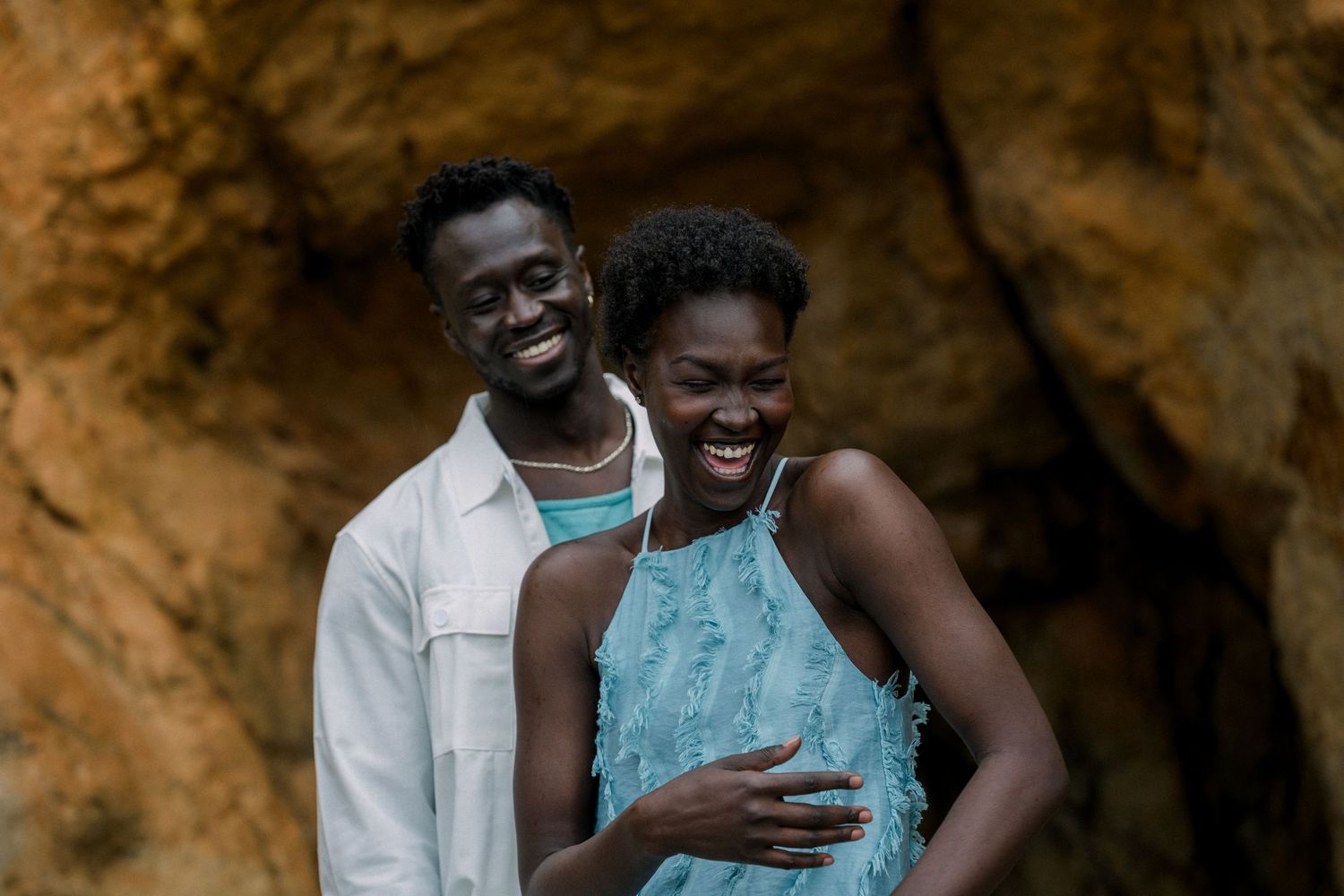 A joyful embrace captured against the backdrop of a golden cave wall.