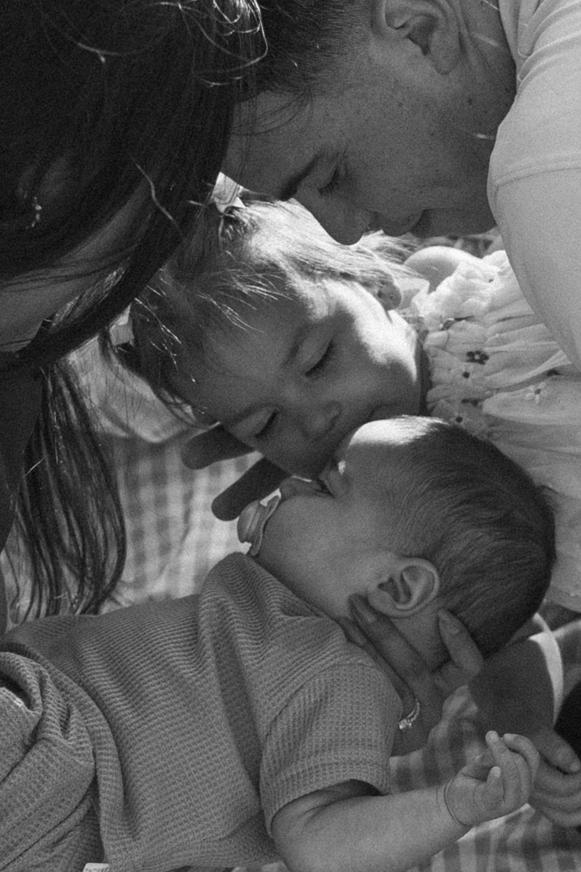A tender moment captured in black and white as family members rest together peacefully.