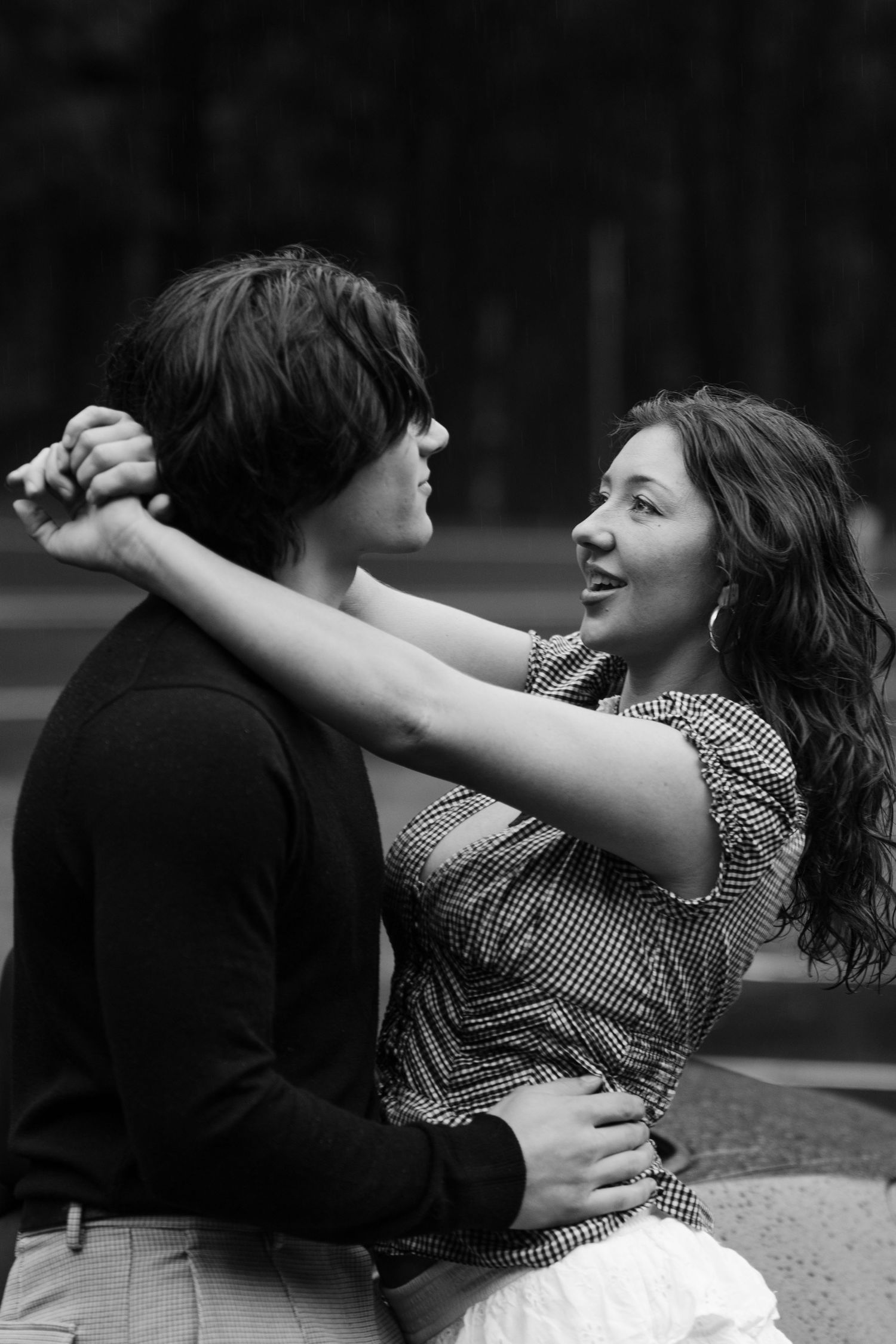 Playful black and white portrait of dancing couple sharing joyful moment.