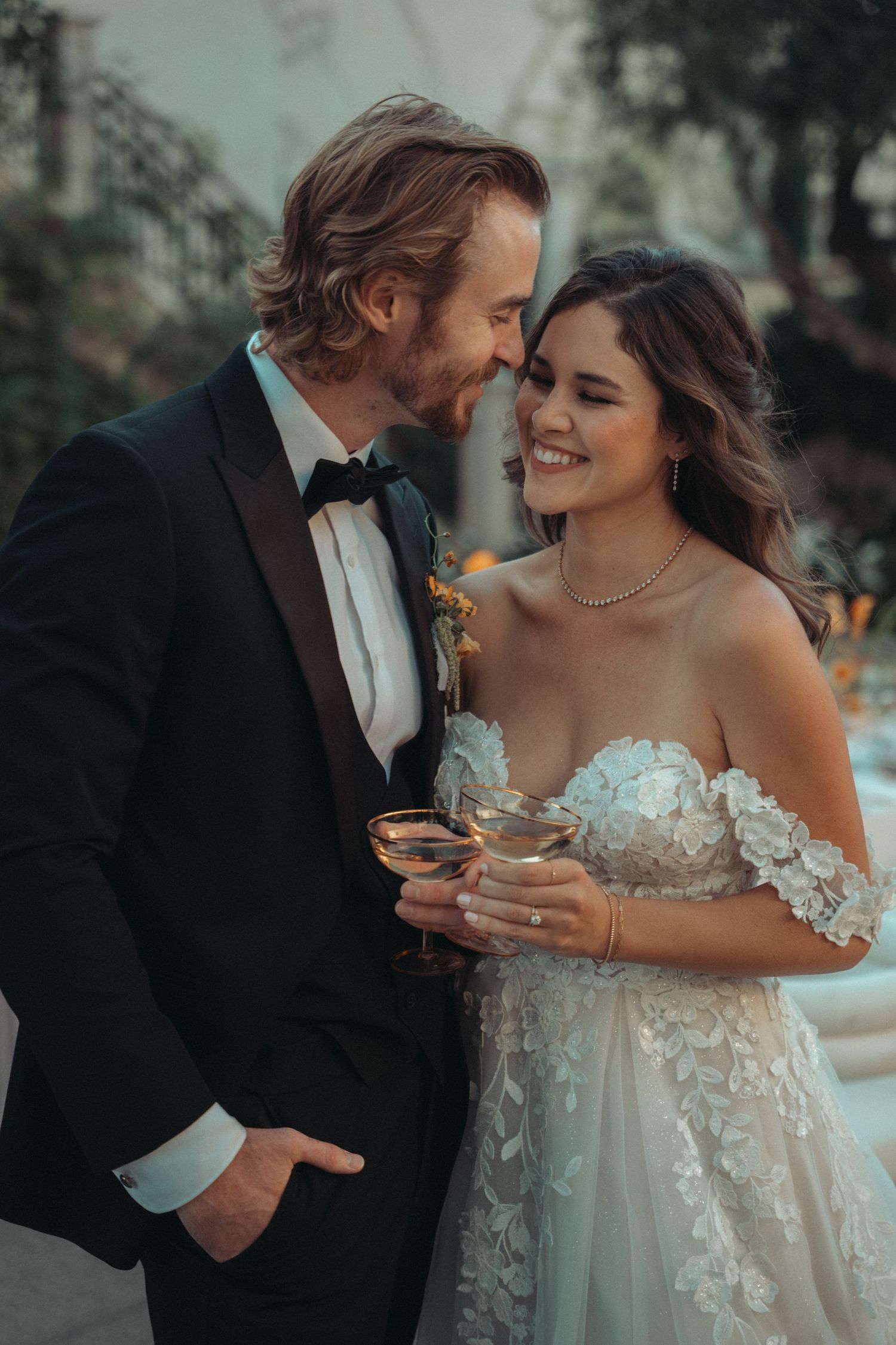 Intimate moment between newlyweds sharing drinks at their elegant outdoor reception.