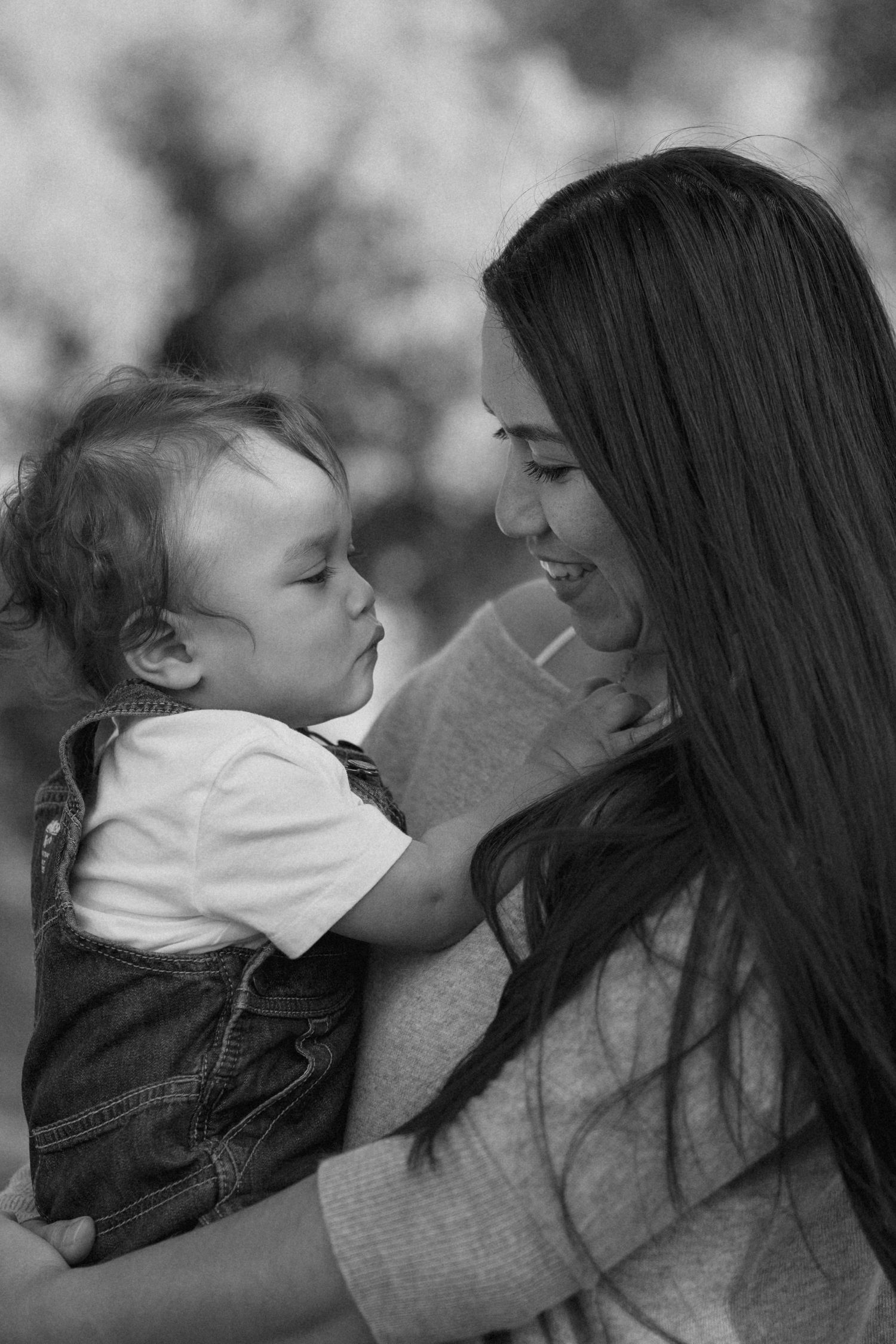 Black and white portrait capturing tender moment between parent and child.
