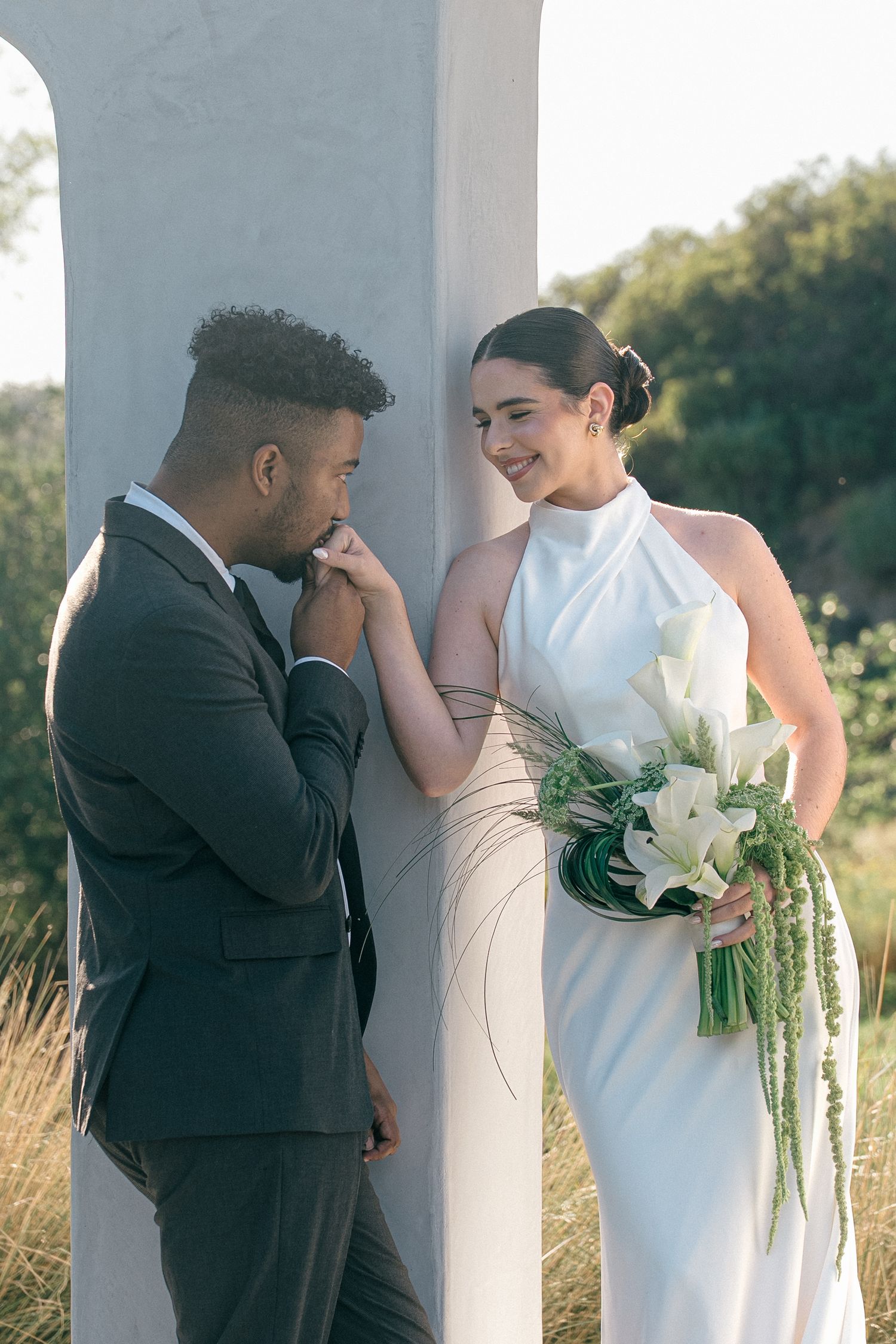 A romantic wedding moment captured in a sequence of four photos showing a couple embracing by white columns at sunset.