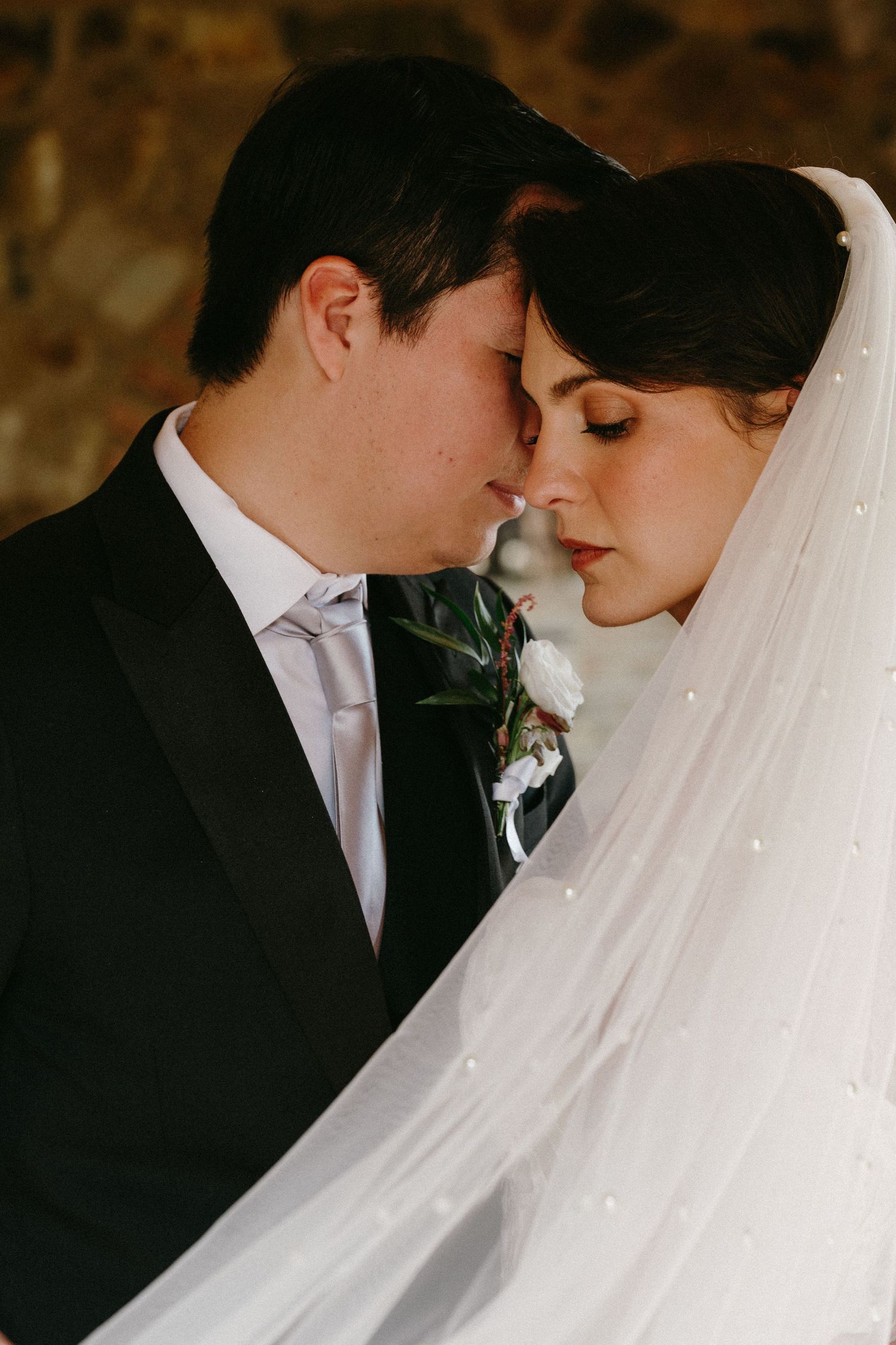 Romantic wedding portrait capturing tender moment between bride and groom.