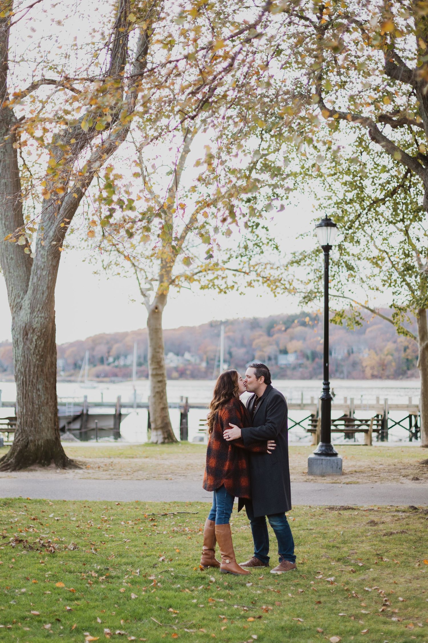 Romantic autumn scene by waterfront with lamp post and fall foliage.