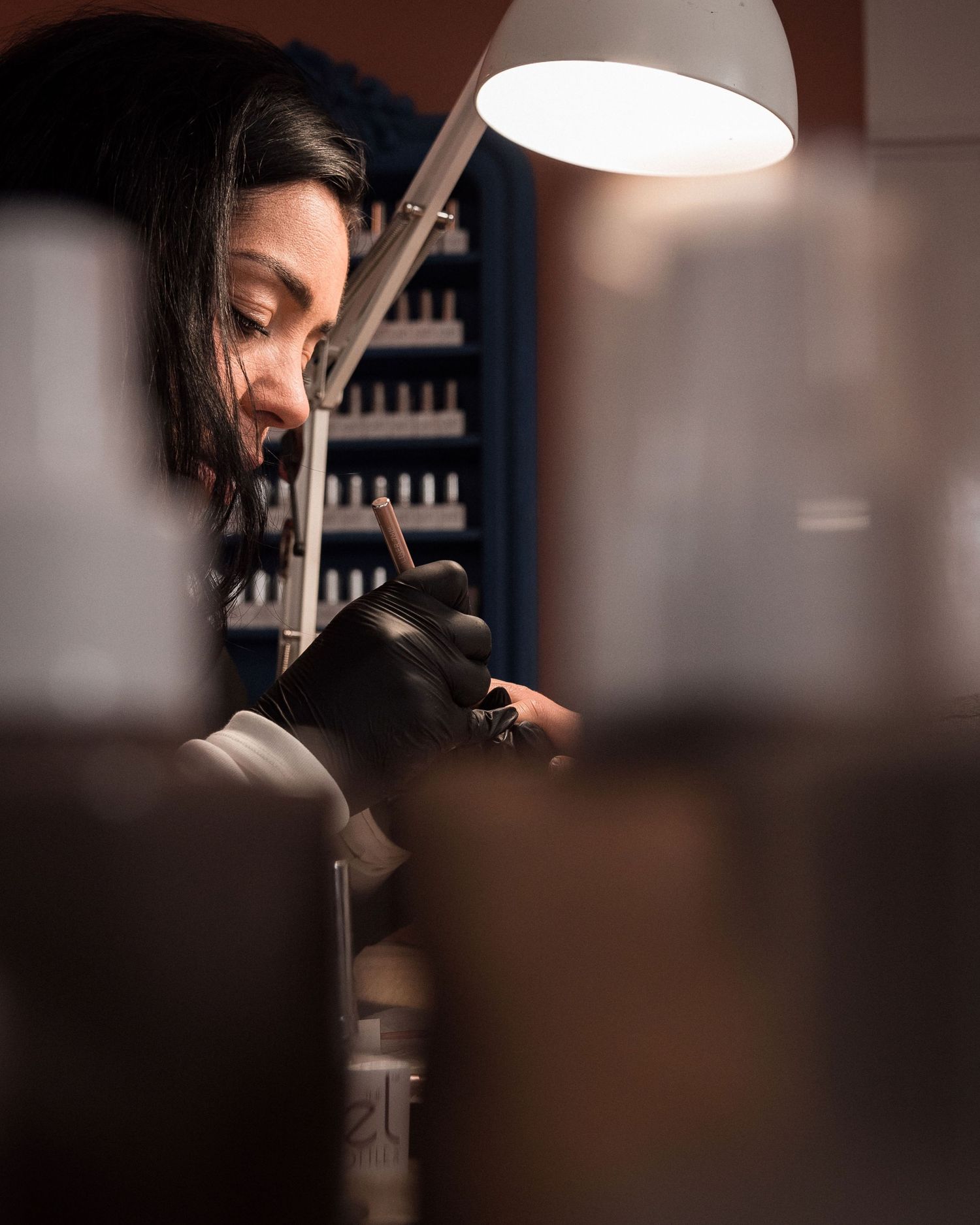 Manucure professionnelle en cours, focus sur la concentration et le geste précis dans un espace de beauté chaleureux