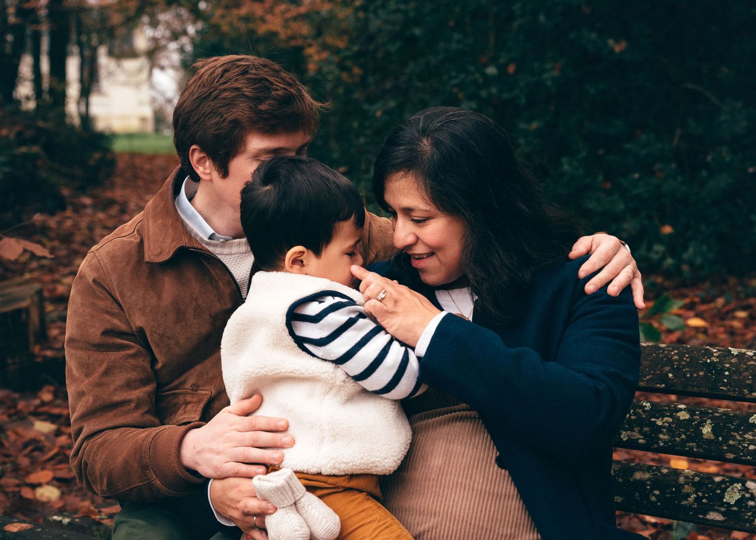 Moment de tendresse entre parents et enfant, photographie de famille en lumière naturelle au parc de la Chantrerie à Nantes