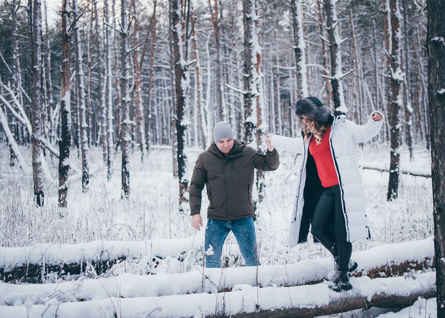 Snowy forest landscape with people enjoying winter activities.