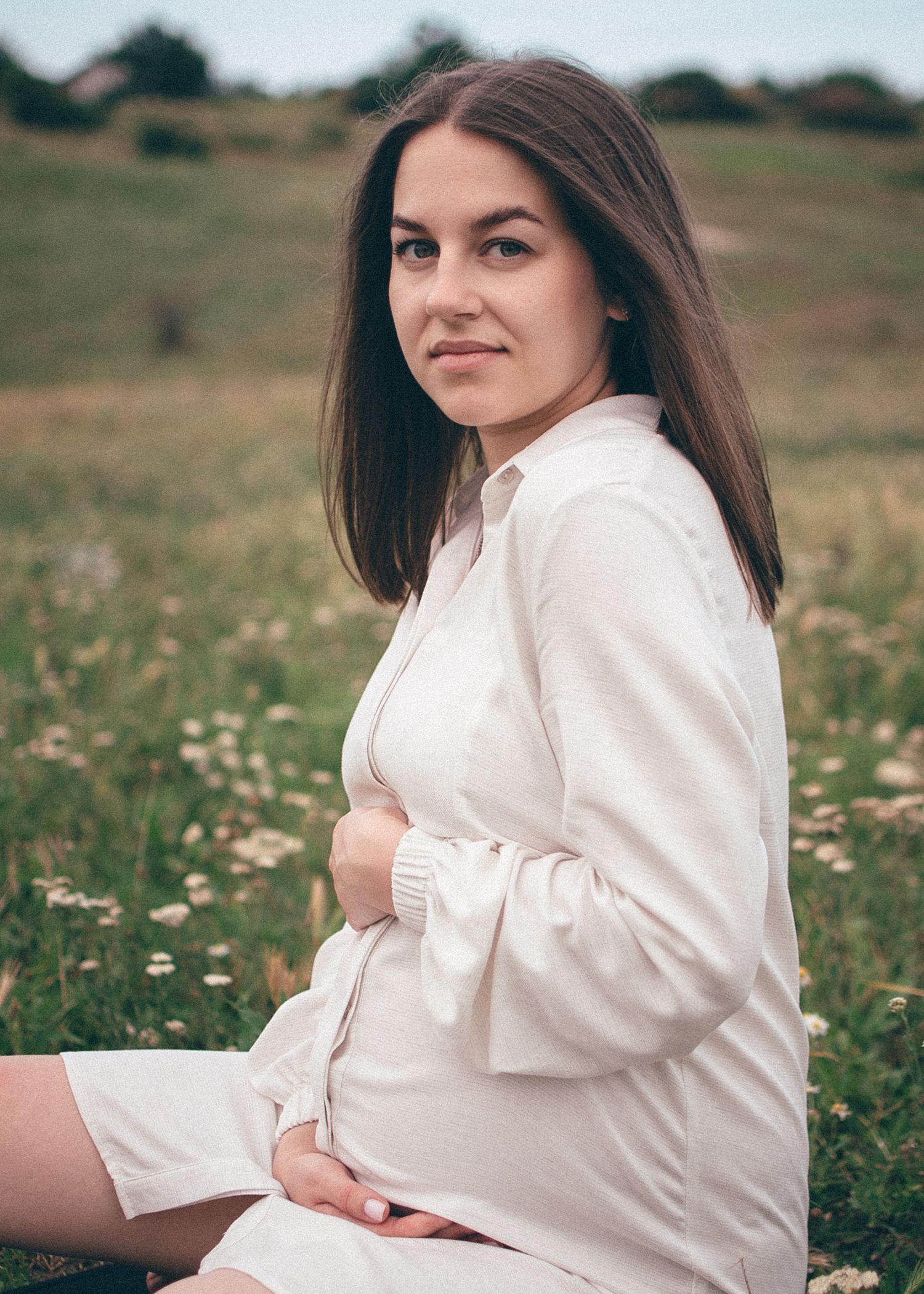 Portrait naturel d’une femme enceinte en extérieur, regard doux et apaisé