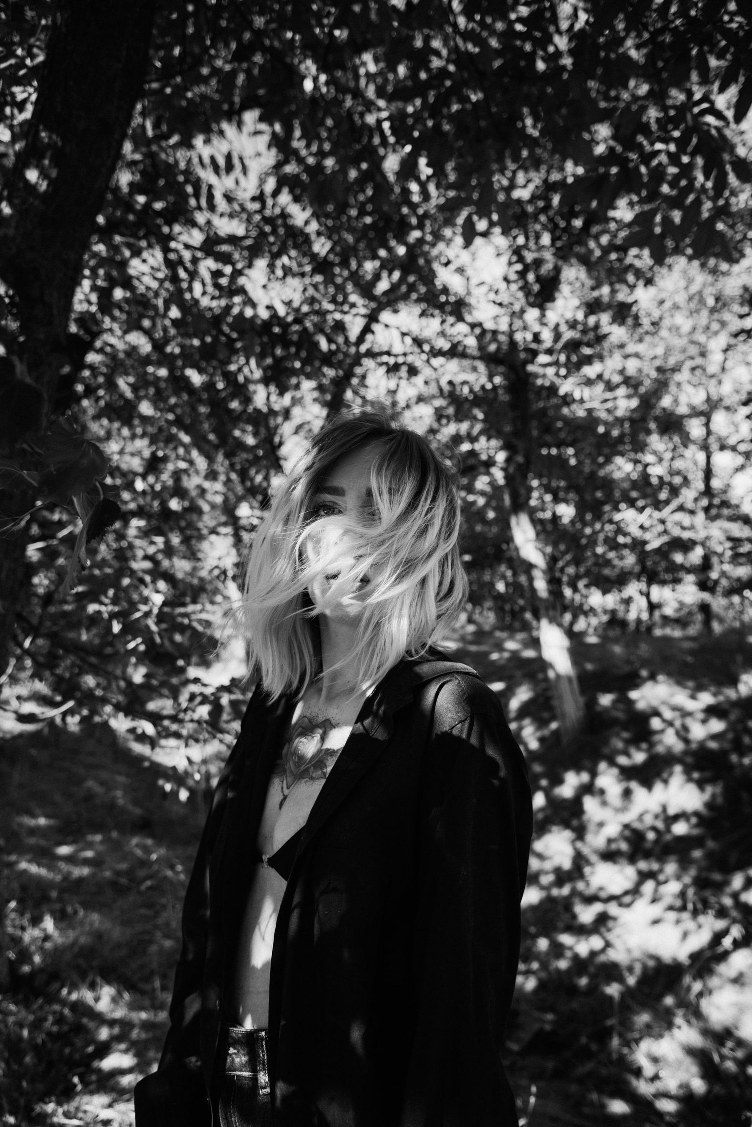 Portrait artistique en noir et blanc d’une femme en extérieur, cheveux au vent et ambiance poétique en Loire-Atlantique