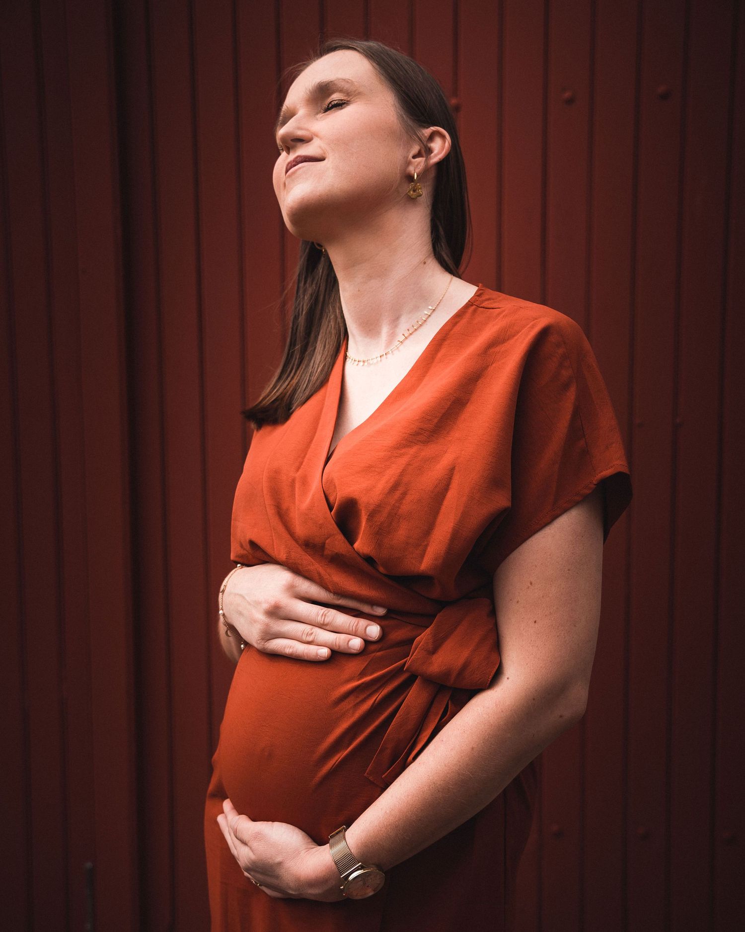 Femme enceinte les yeux fermés, lumière douce et ambiance intimiste lors d’une séance photo en Loire-Atlantique