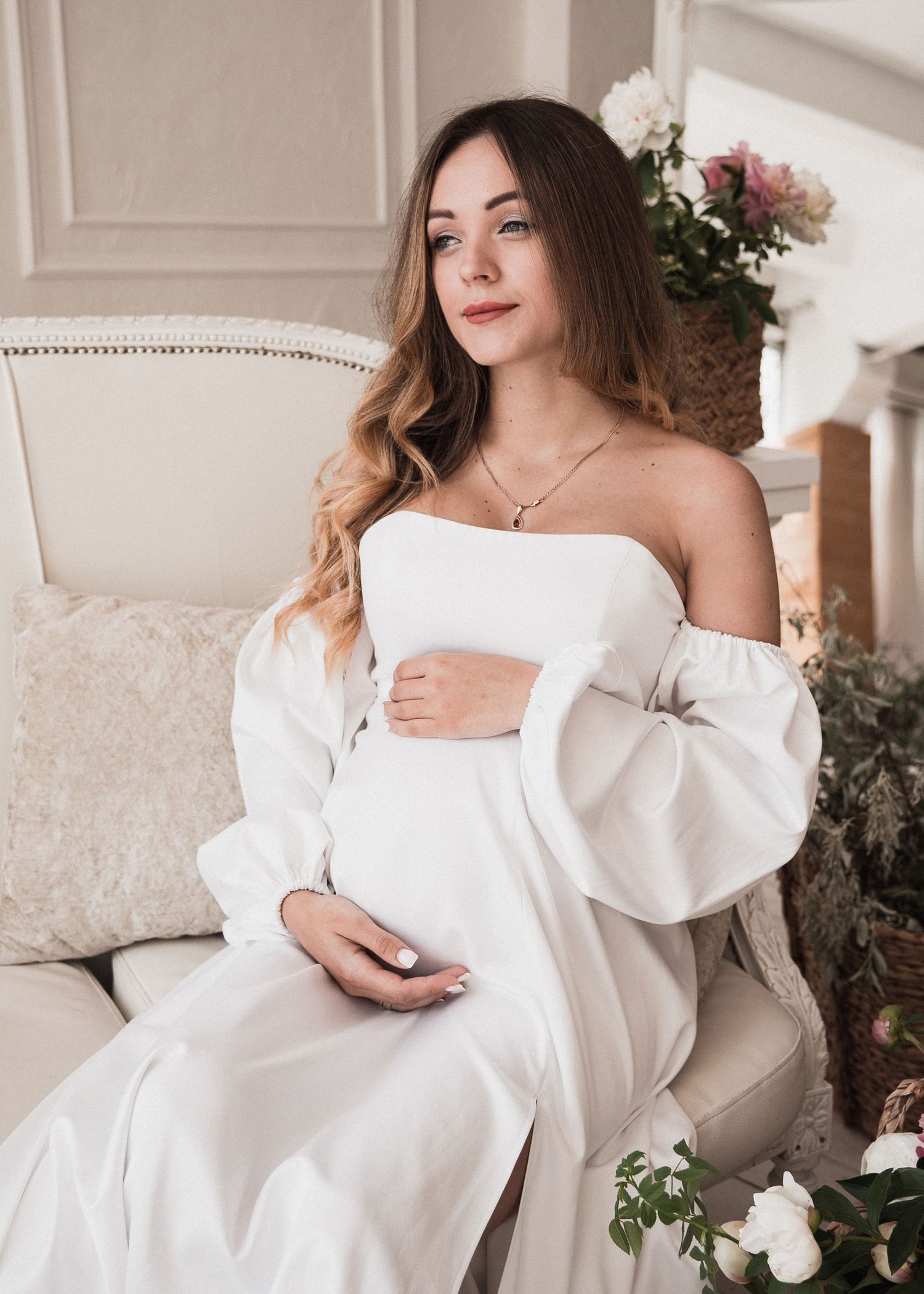 Femme enceinte assise dans un intérieur lumineux, portrait maternité doux et élégant