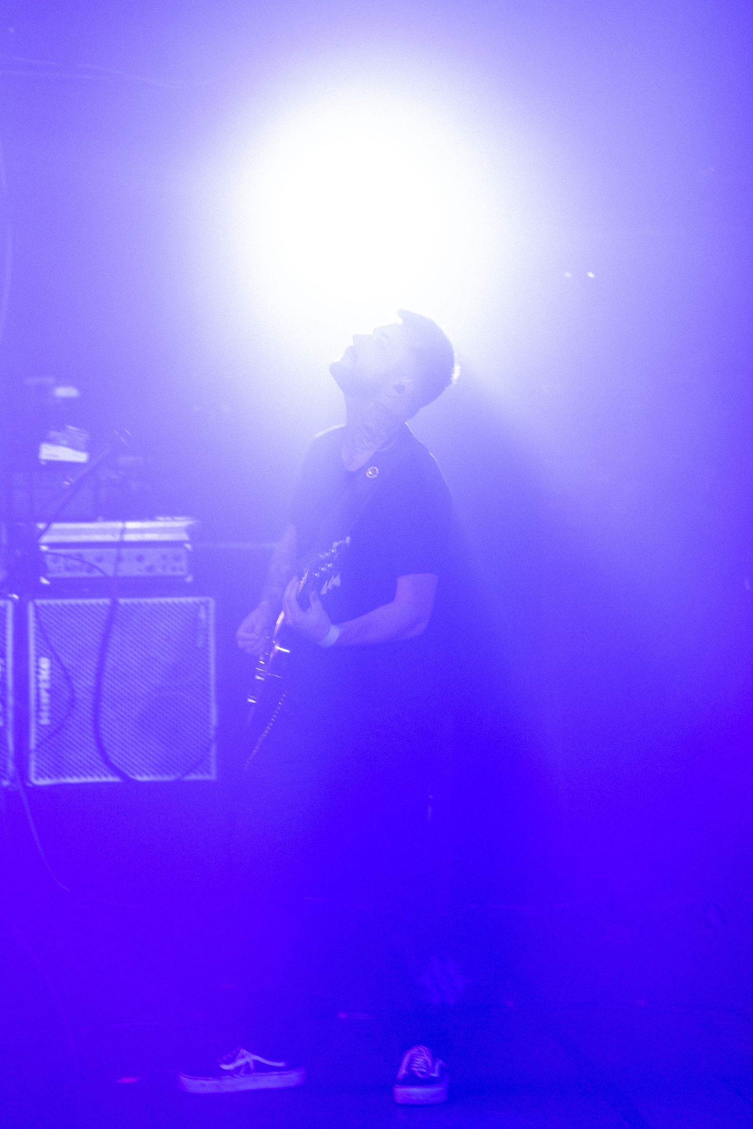 Musicien sur scène enveloppé de lumière bleue, photographie artistique de concert à l’ambiance onirique