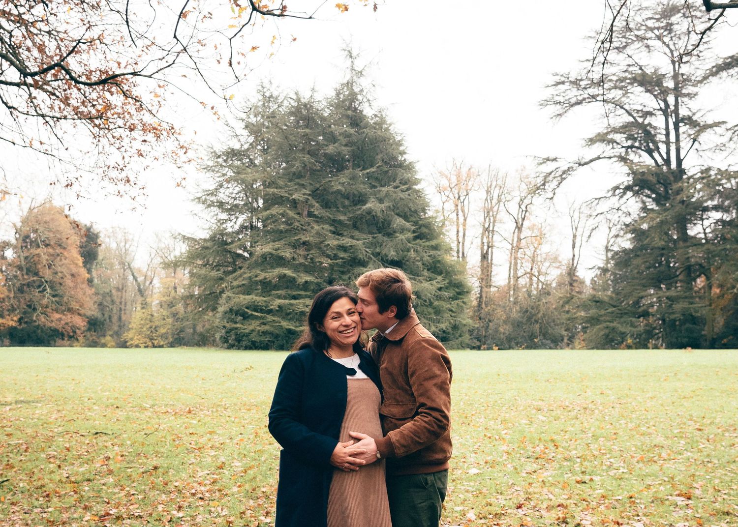Couple attendant un enfant dans un parc, moment tendre et naturel lors d’une séance photo grossesse à la Chantrerie à Nantes
