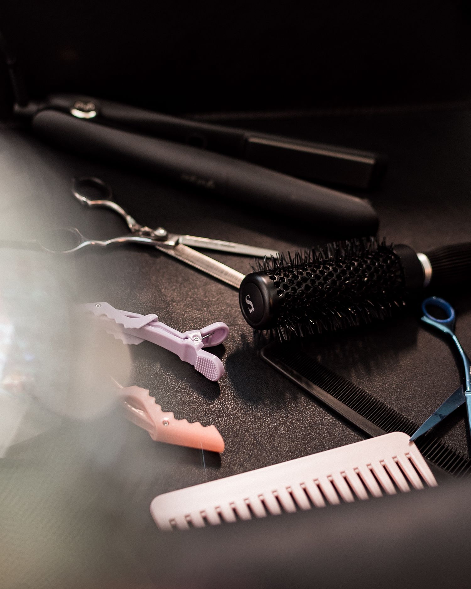 Outils de coiffure disposés sur un plan de travail, photographie de détails en lumière douce dans un salon à Nantes